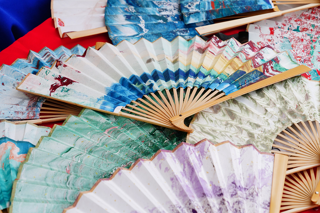 A photo taken on June 8, 2024 in Beijing's Panjiayuan antique market shows a variety of marbled fans in different colors. /CFP