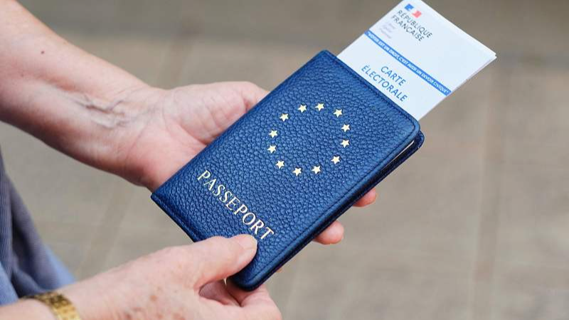 A voter holds an identification document and electoral card before voting in the European Parliament election at a polling station in France's Pacific territory of New Caledonia, June 9, 2024. /CFP