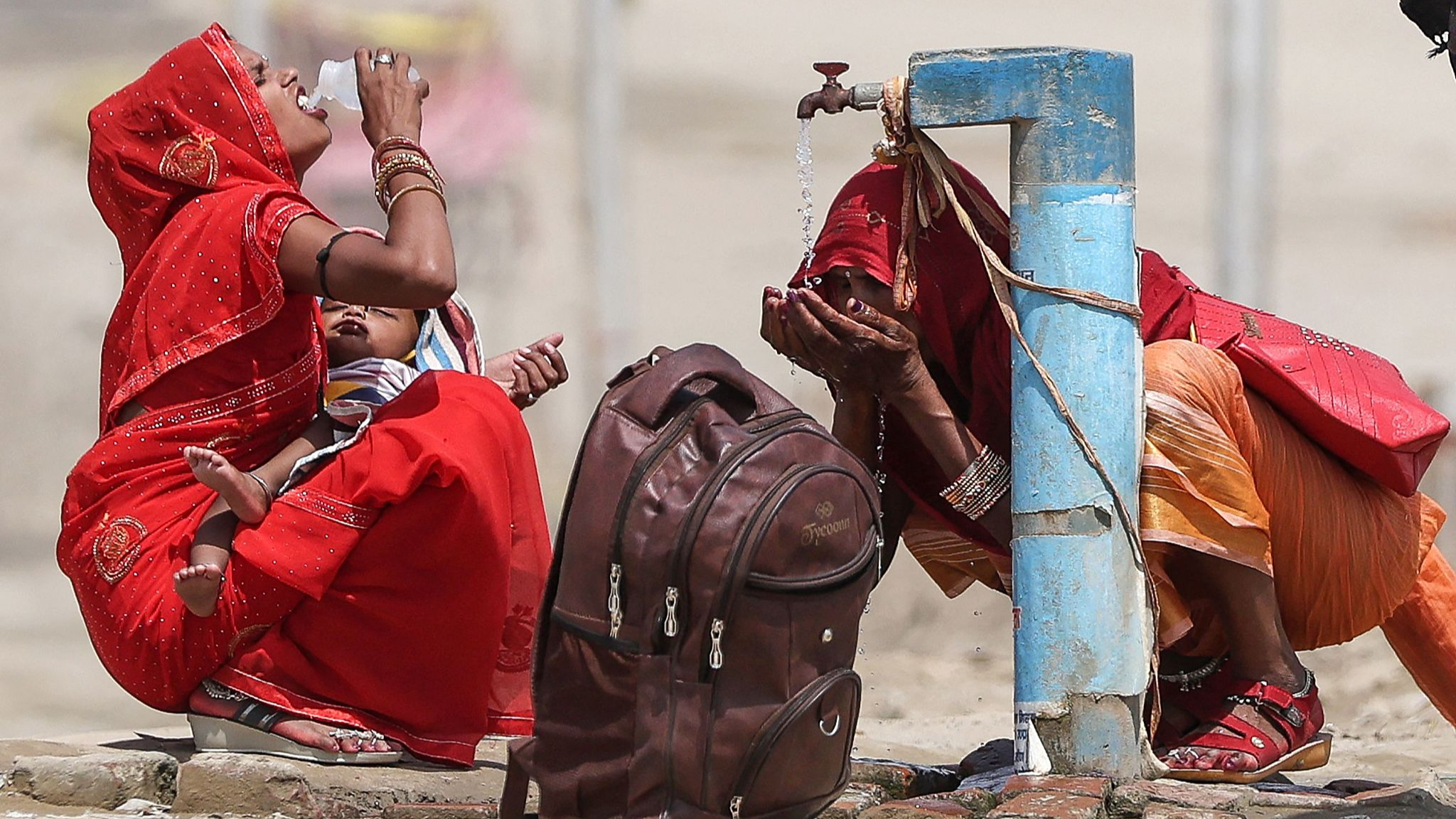 Women drink tap water on a hot summer afternoon during a heat wave in Prayagraj, India, June 10, 2024. /CFP