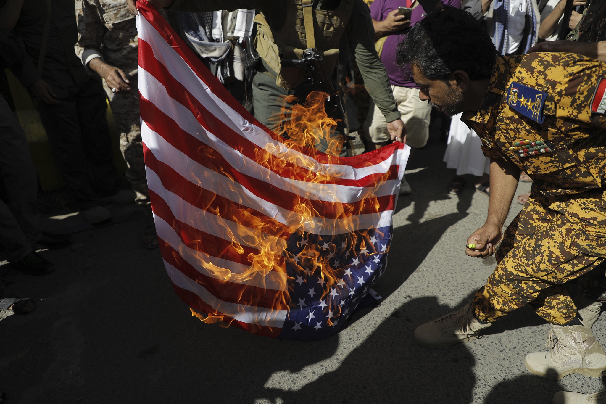 Houthi supporters burn an U.S. flag during a military march marking the anniversary of Yemeni unity in Sanaa, Yemen, May 22, 2024. /CFP