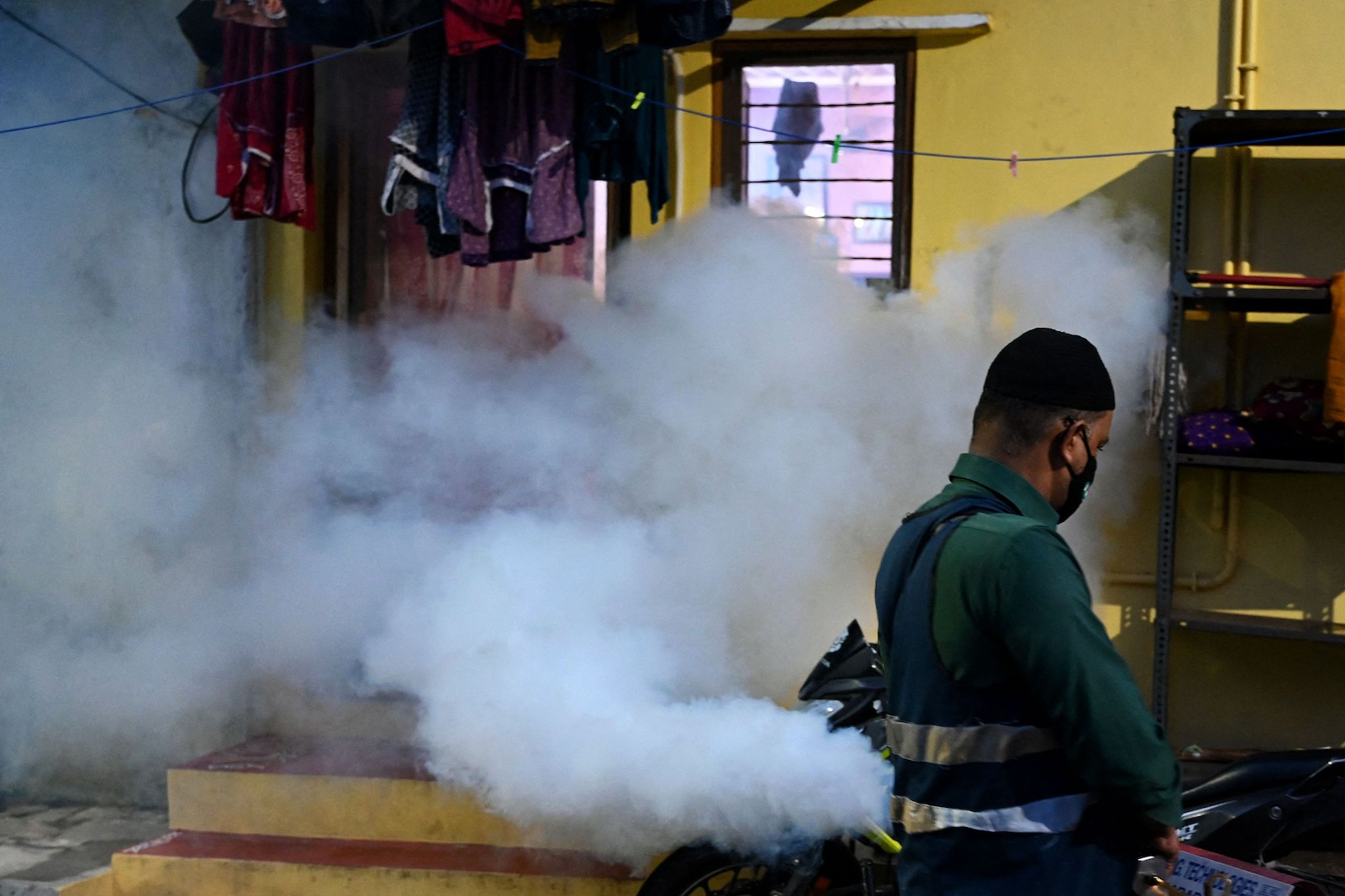 A municipal worker fumigates a housing colony as a preventive measure against mosquito-borne diseases in Hyderabad, India, September 4, 2023. /CFP