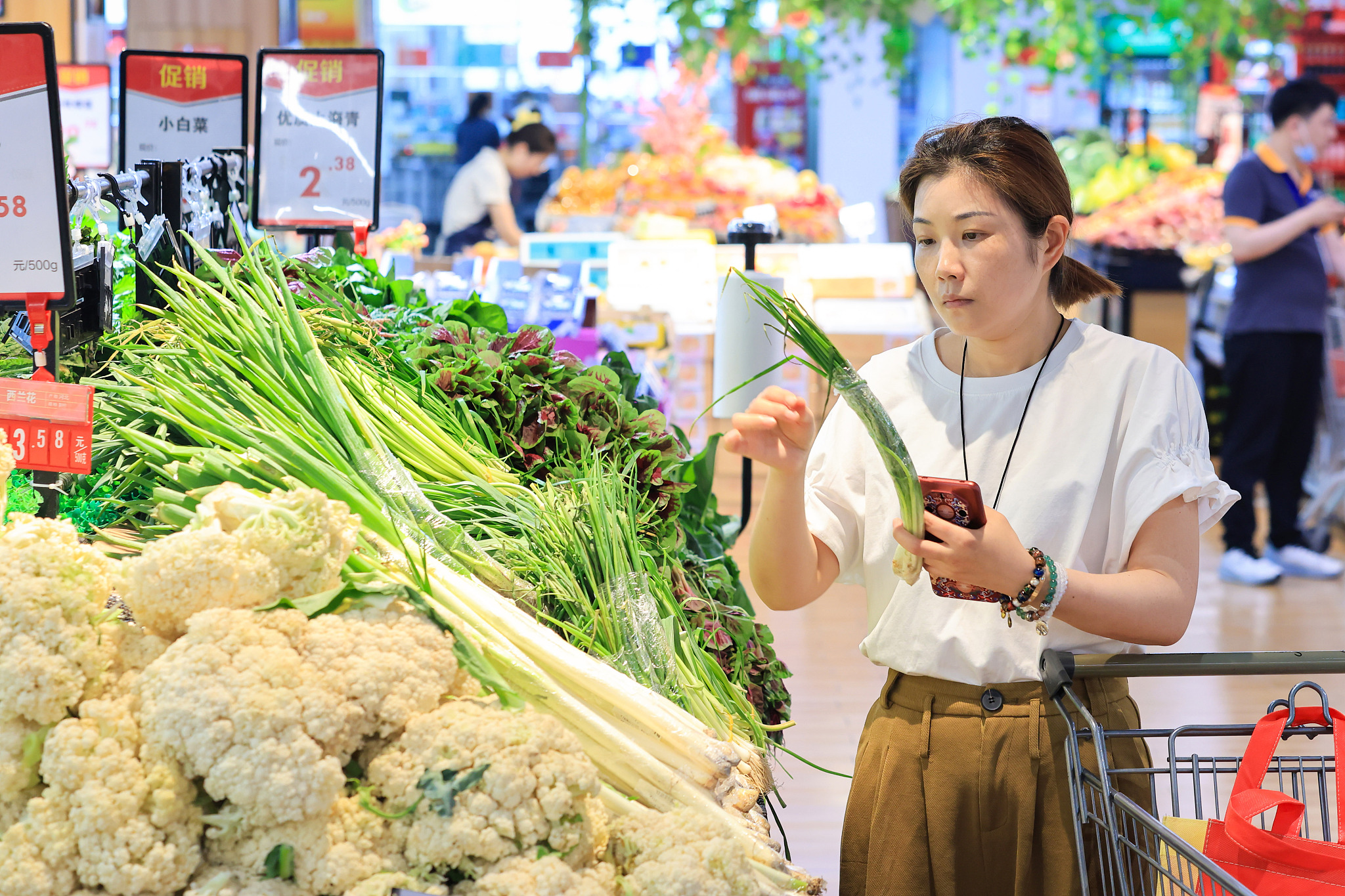 A consumer picking up vegetables in Nanjing, Jiangsu Province on June 12./ CFP