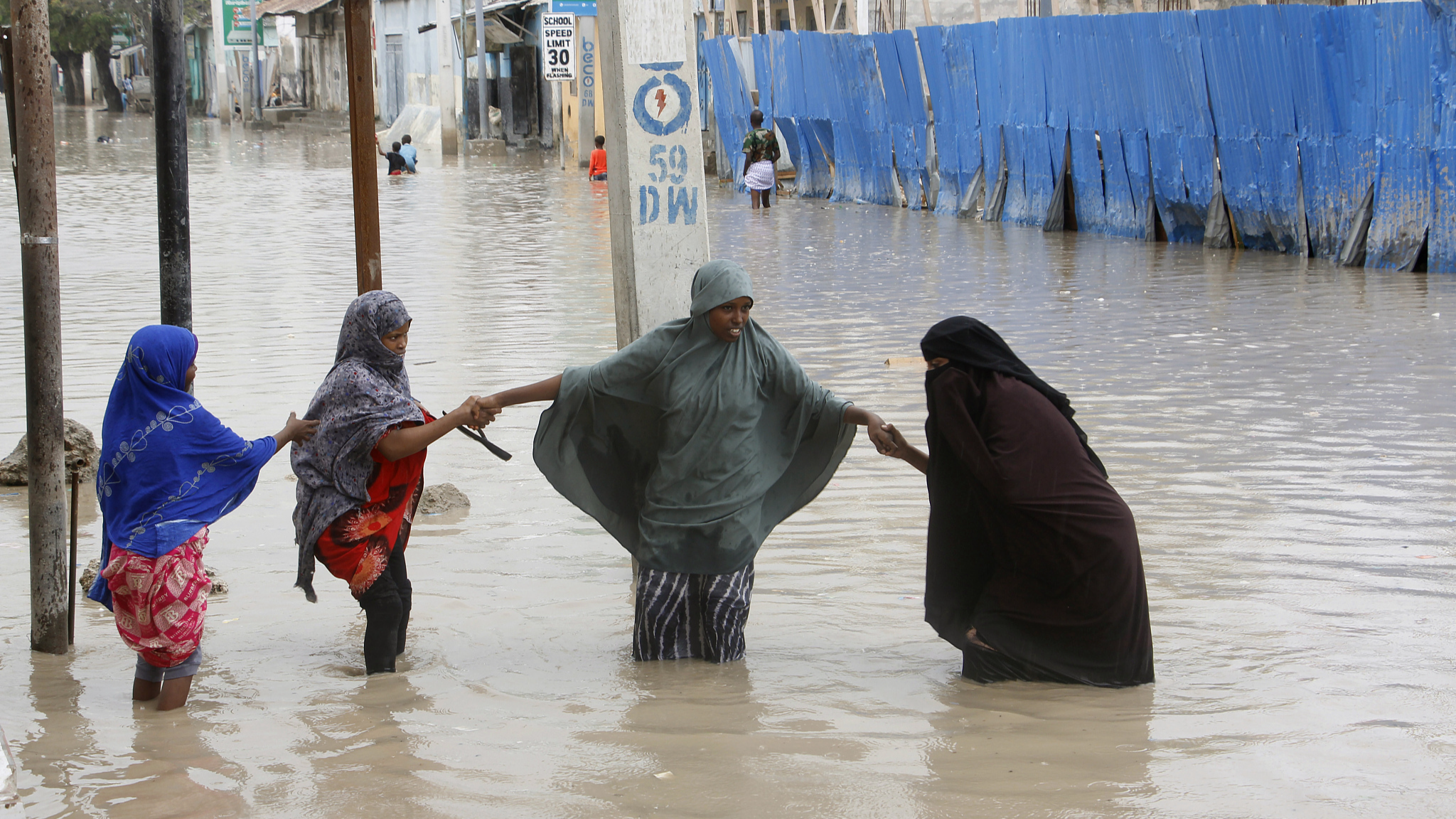 Women walk through flood water after heavy rainfall in Mogadishu, Somalia, November 20, 2023. /CFP