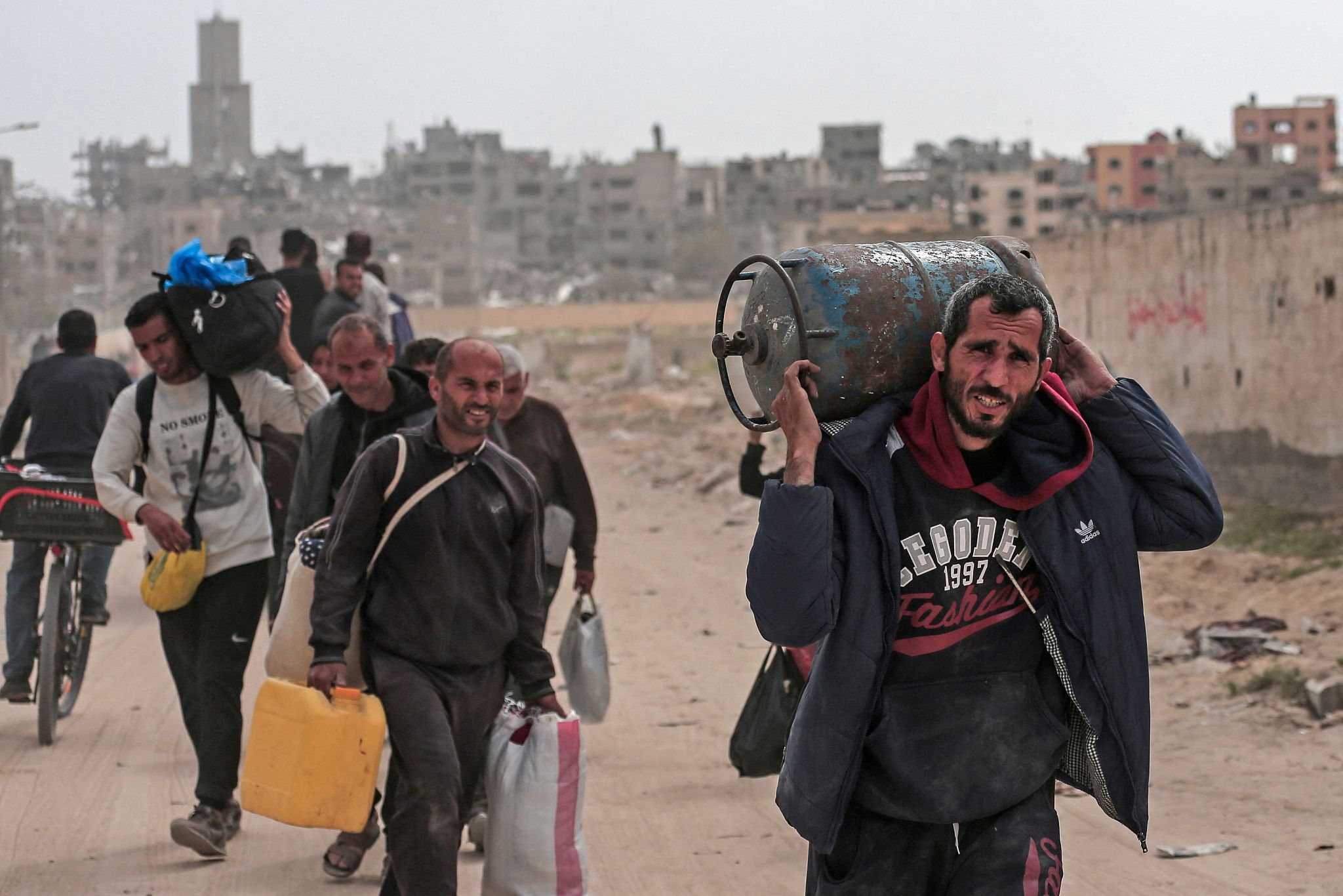 Displaced Palestinians carry their belongings through a street in Khan Yunis in the southern Gaza Strip, March 6, 2024. /CFP