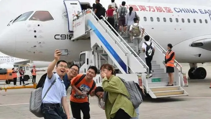 Passengers take pictures in front of a C919 aircraft on June 14, 2024. /CMG
