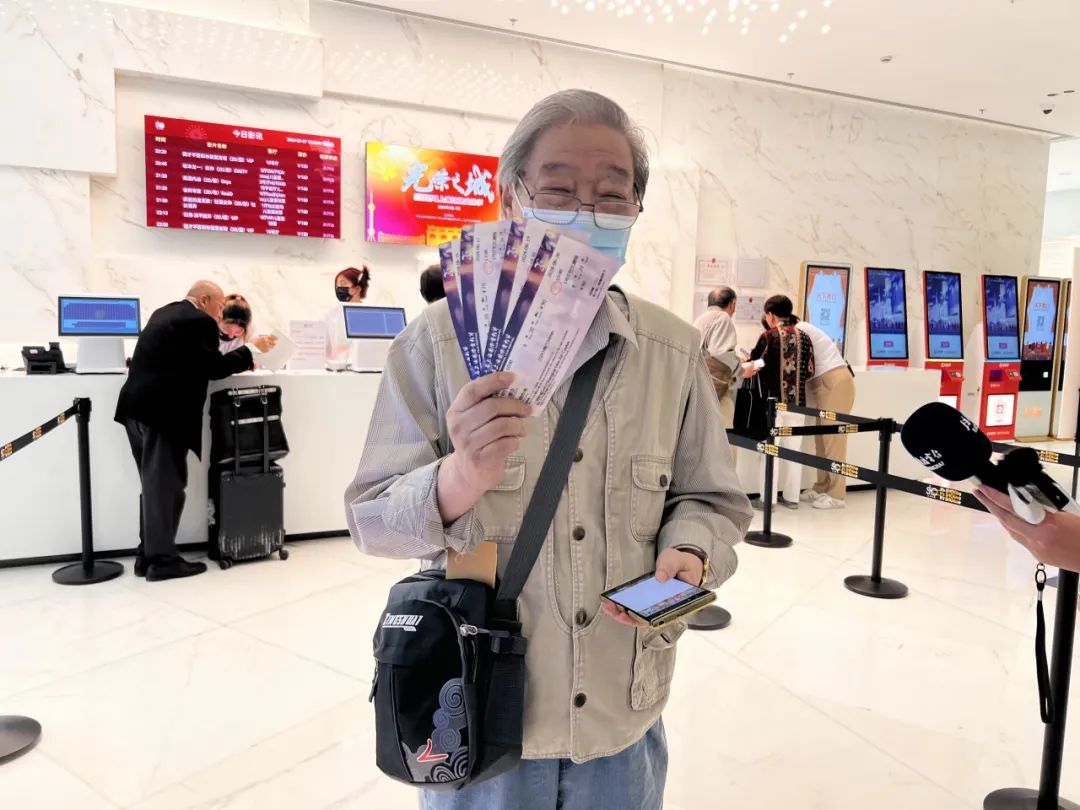An undated photo shows a film enthusiast just purchased film tickets at a cinema in Shanghai. /SIFF