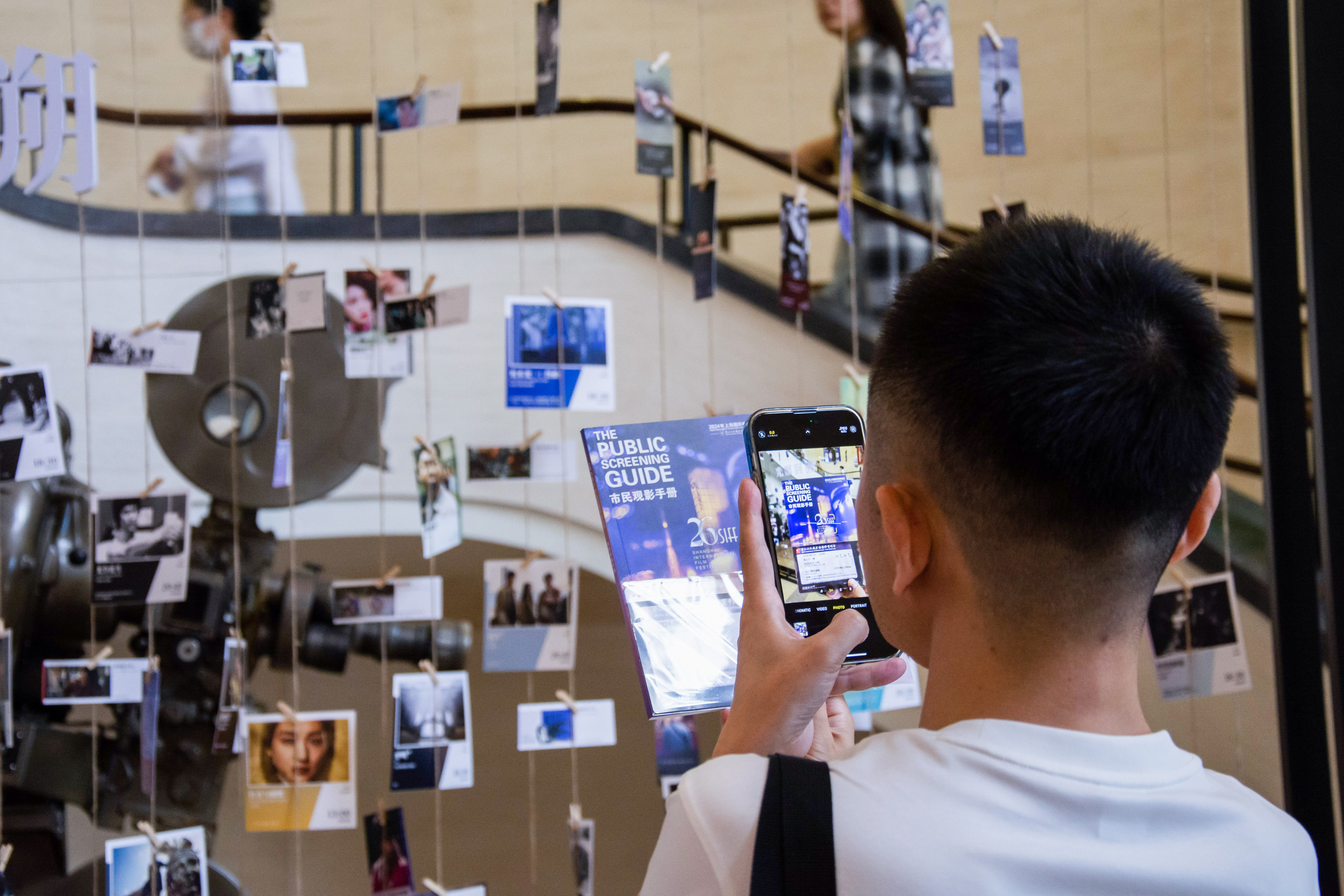 A man takes a photo of the screening guide of the 26th Shanghai International Film Festival at Majestic Theater, Shanghai, China, June 15, 2024. /CFP