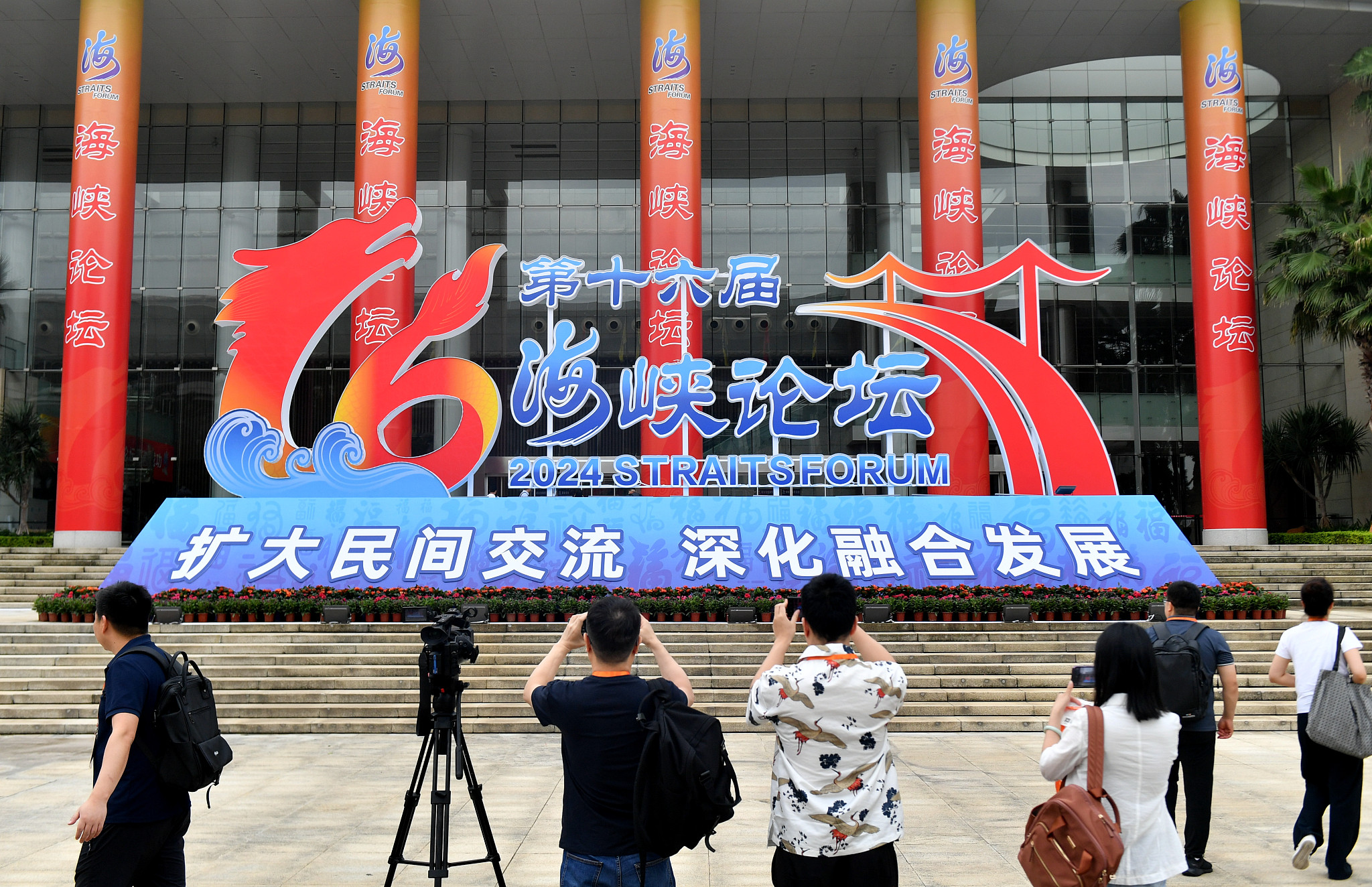 Journalists take photos in front of the primary venue of the 16th Straits Forum in Xiamen City, southeast China's Fujian Province, June 14, 2024. /CFP