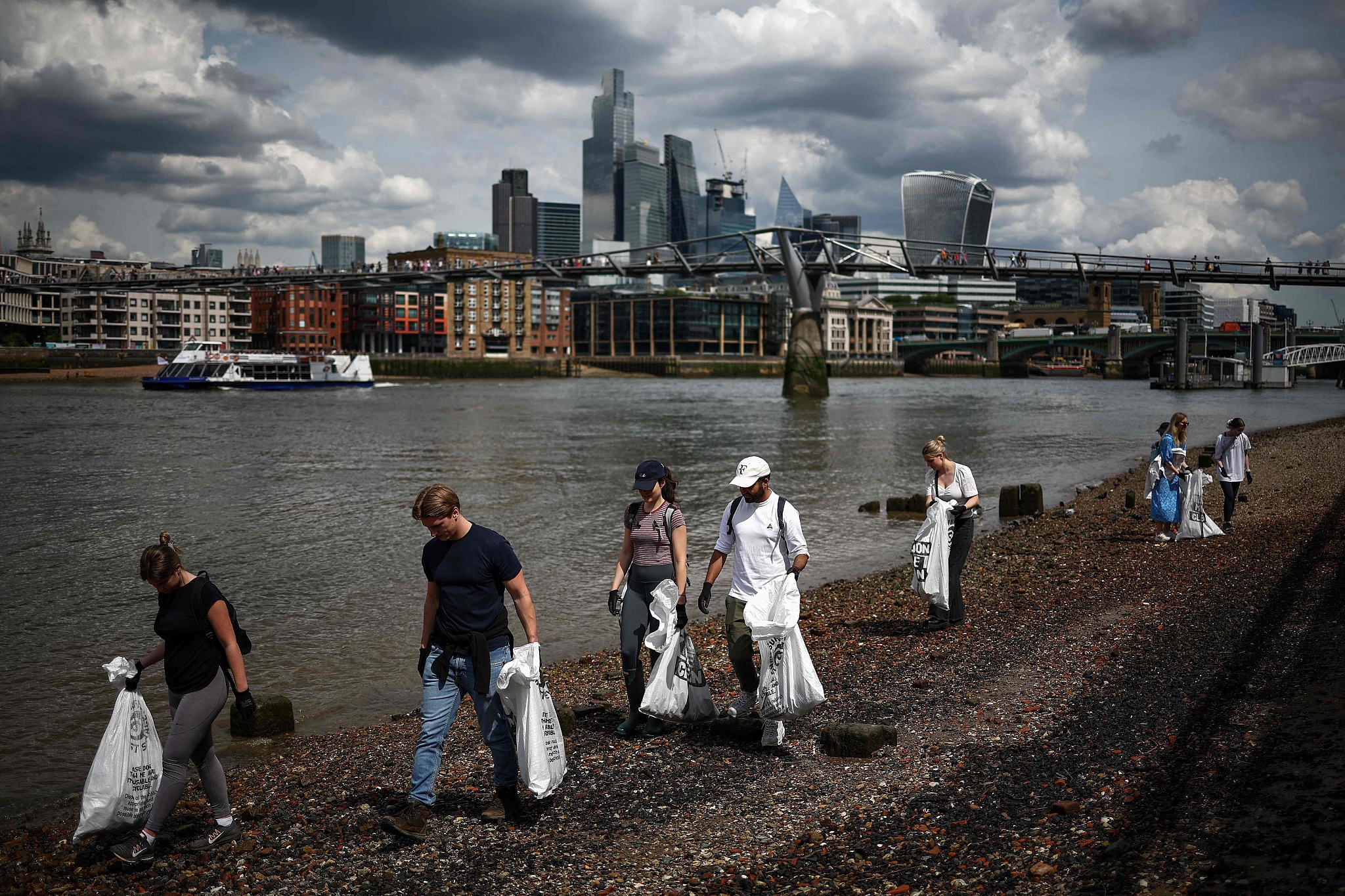 Activists of Surfers Against Sewage, a marine conservation charity, take part in a beach clean-up on the banks of the River Thames, London, UK, May 17, 2024. /CFP