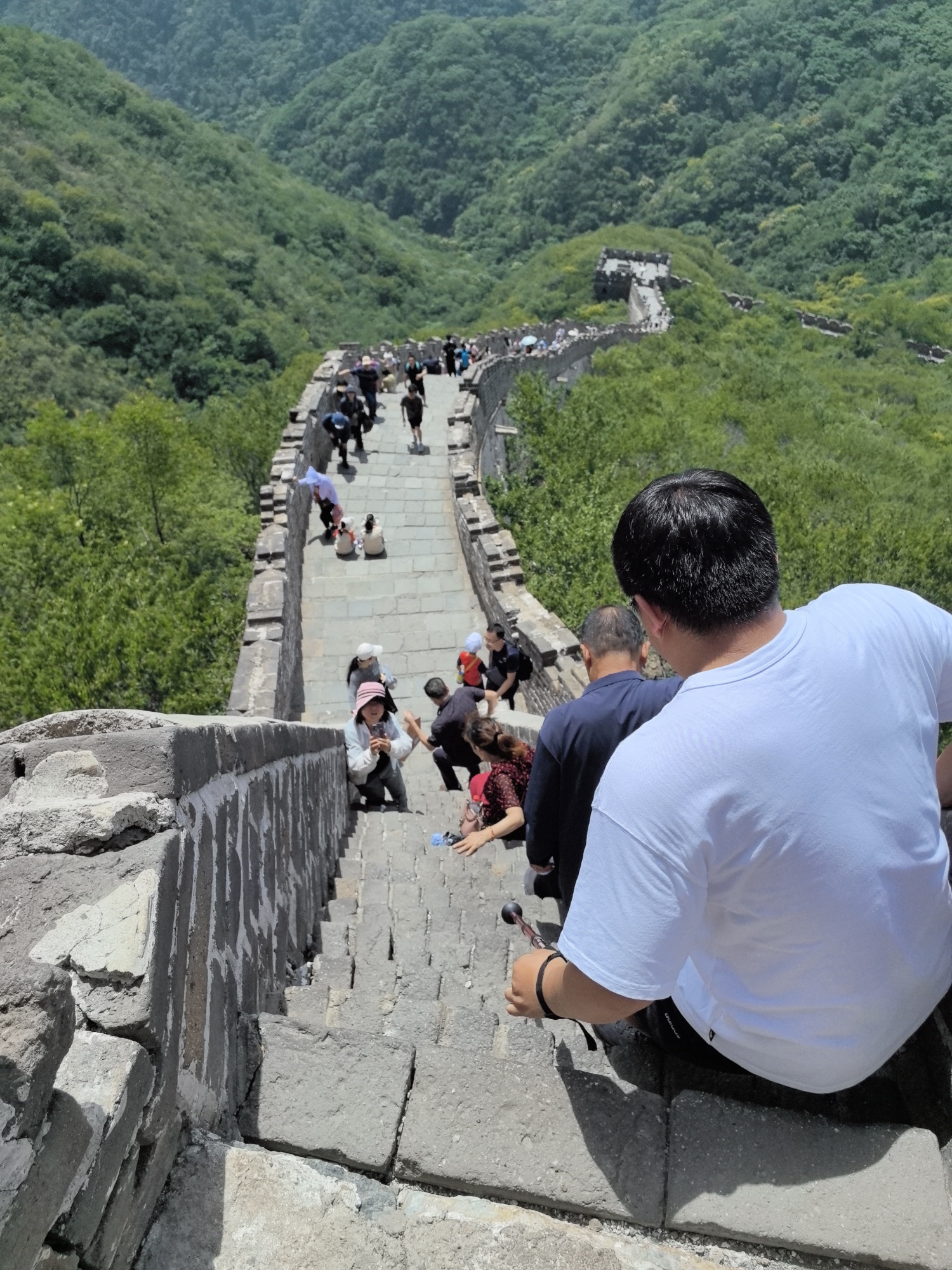 Tourists walk down steep stairs of the Mutianyu section of the Great Wall in Beijing on June 10, 2024. /CGTN