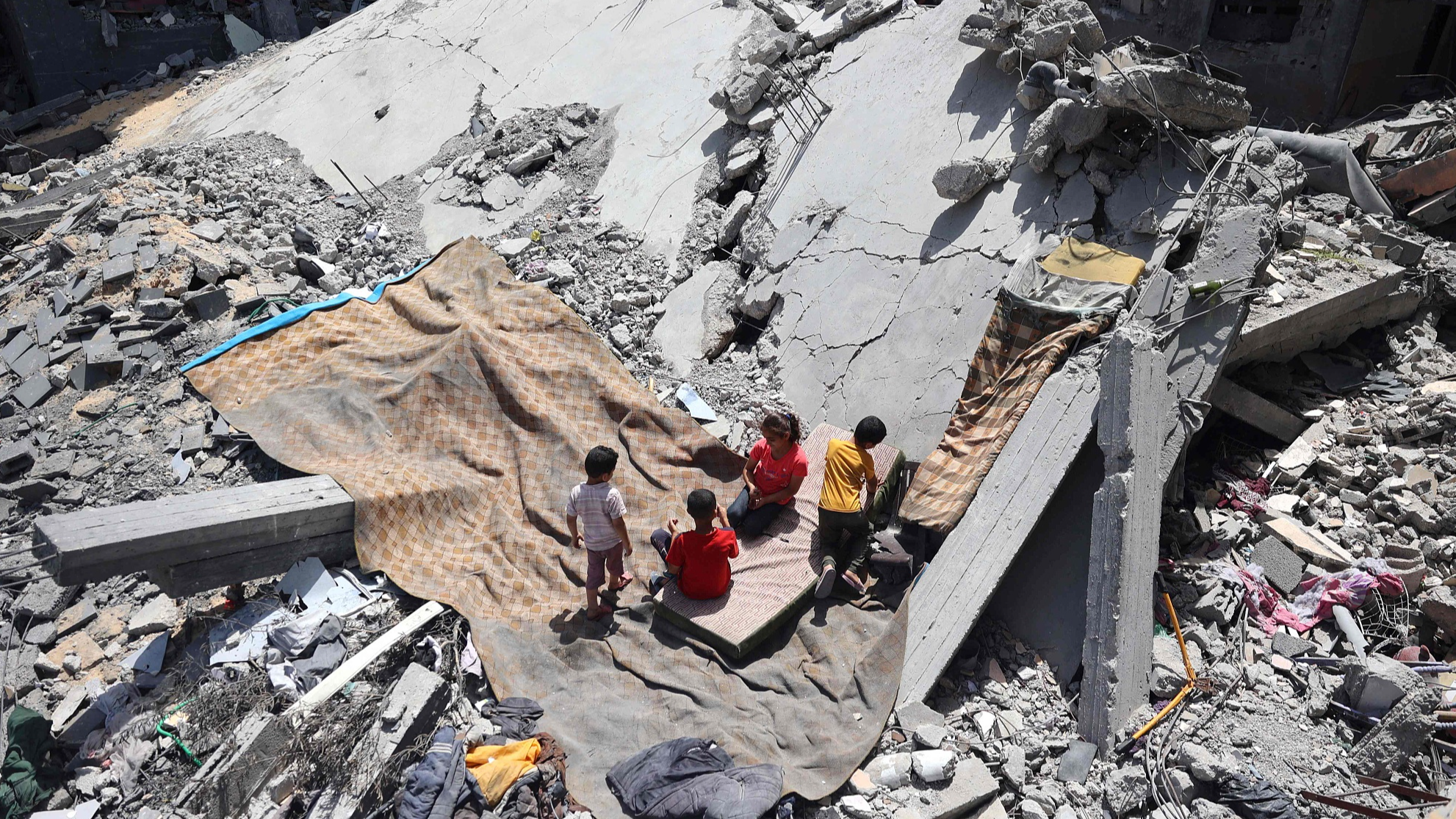Palestinian children play on the site of a destroyed building, purportedly where Israeli hostages were held and rescued during an Israeli military operation, in the Nuseirat refugee camp, in the central Gaza Strip on June 15, 2024. /CFP