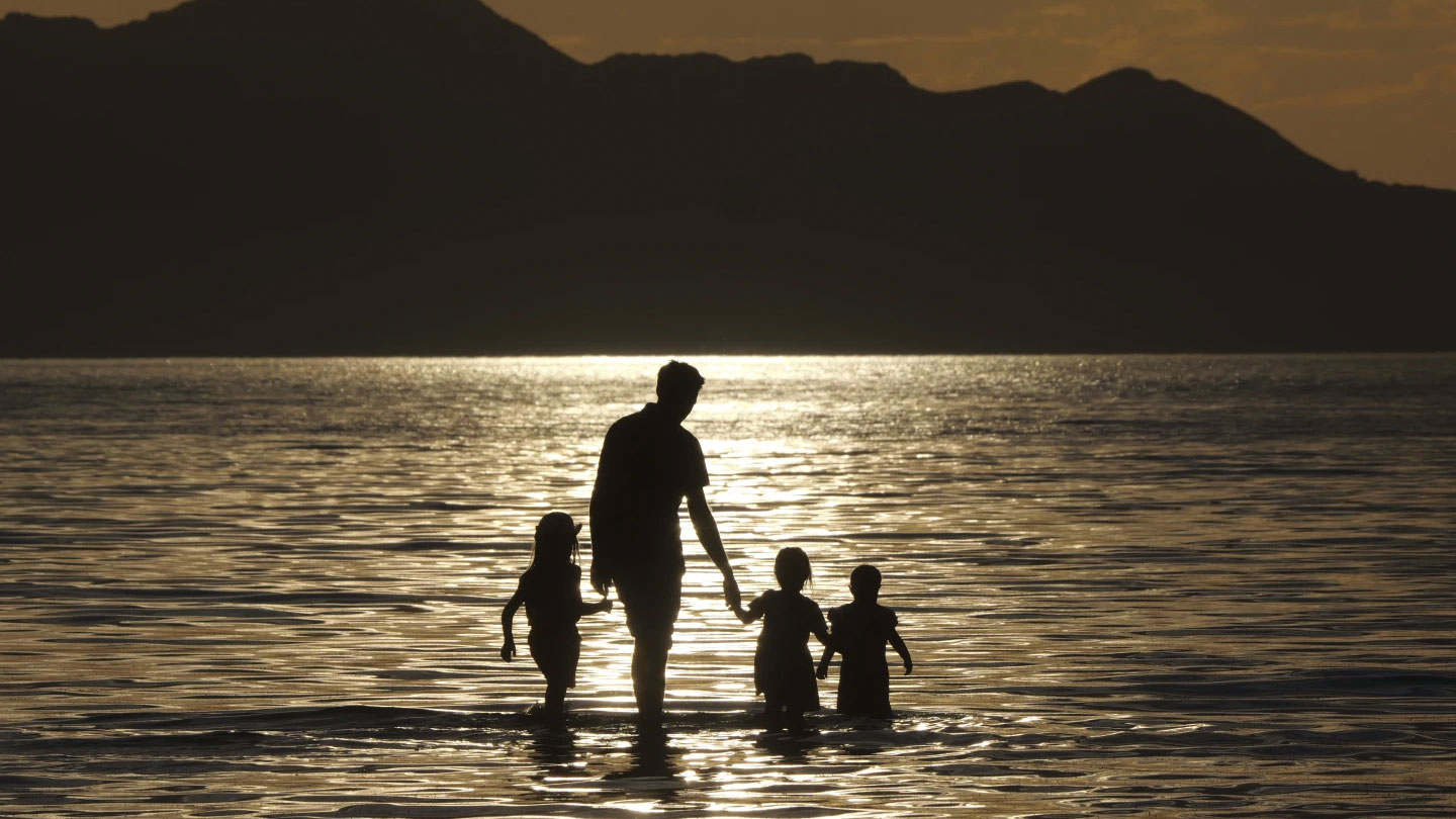 A family walks in the water during sunset at the Great Salt Lake, Utah, U.S., June 13, 2024. /AP