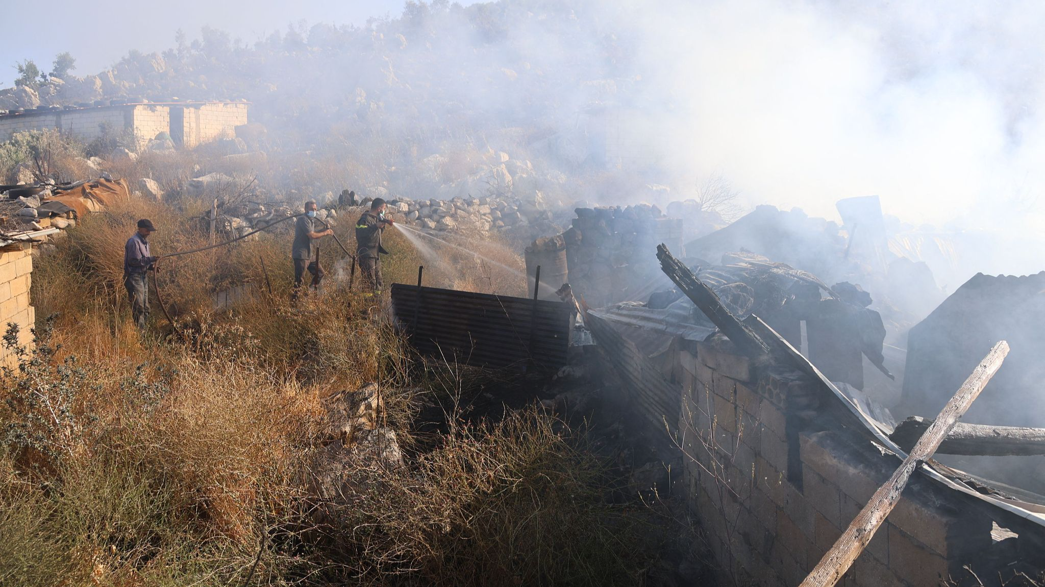 Lebanese civil defense firefighters and residents douse a fire resulting from Israeli military shelling in the village of Shebaa, close to the southern Lebanese border with Israel, June 14, 2024. /CFP