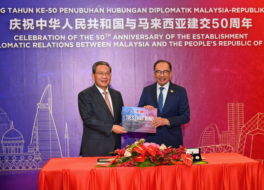 Chinese Premier Li Qiang (L) and Malaysian Prime Minister Anwar Ibrahim present souvenirs to each other, Kuala Lumpur, Malaysia, June 19, 2024. /Xinhua