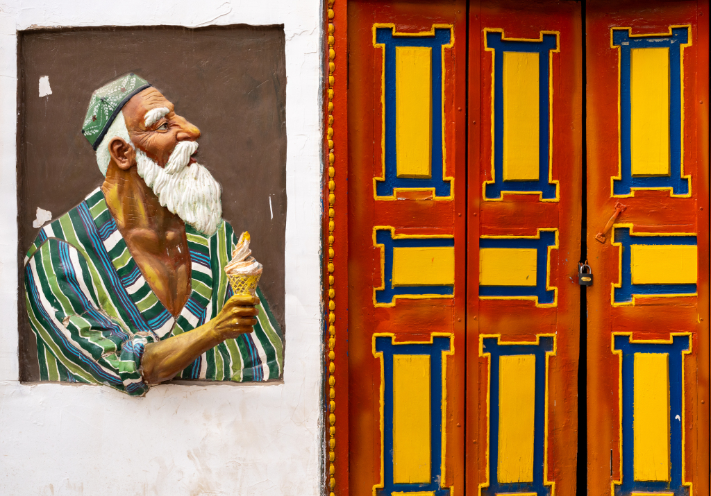 A vivid wall mural and a colorfully painted door are pictured in Aksu, Xinjiang on May 20, 2024. /CFP