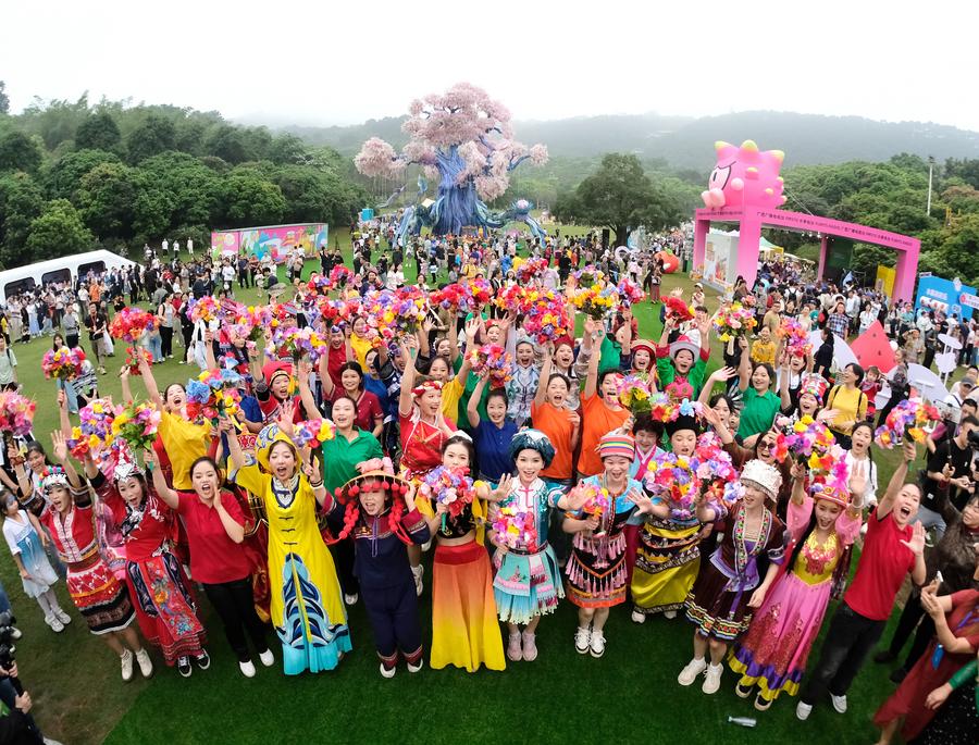 People pose for a group photo during a celebration of the Sanyuesan Festival in Nanning, capital of south China's Guangxi Zhuang Autonomous Region, April 11, 2024. /Xinhua