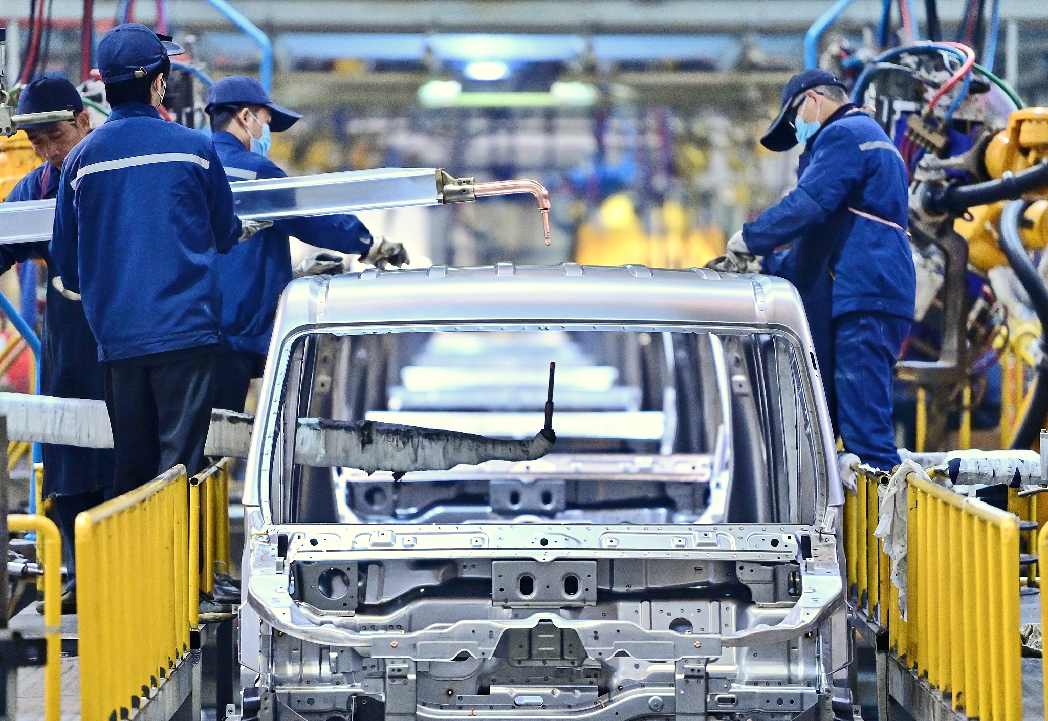 Workers are welding and assembling new energy electric vehicles on a production line for export to South American countries in Jiangxi Province on December 25, 2023. /CFP