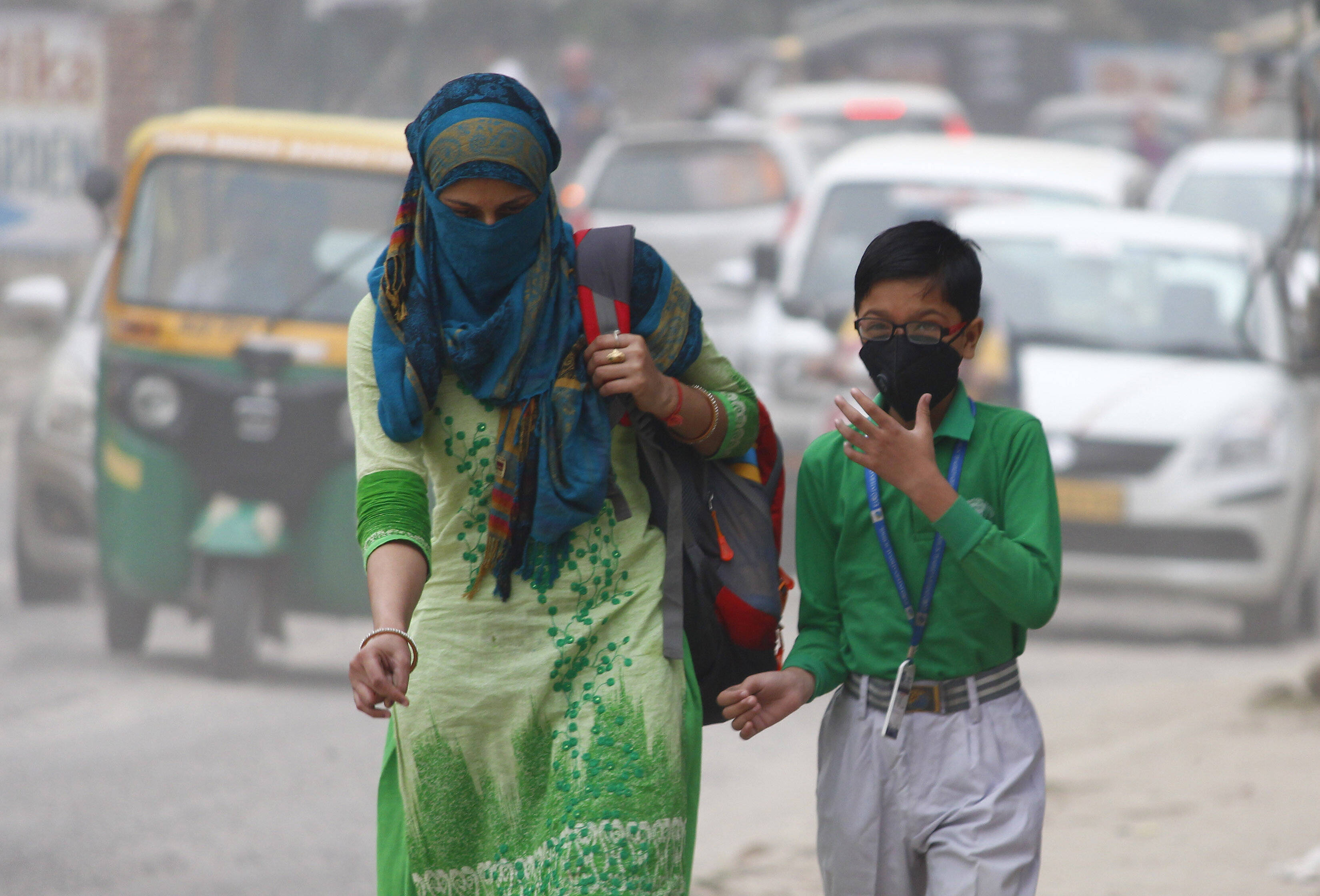 A woman and a child walk with their face covered due to rise in pollution in Gurugram, India, October 30, 2019. /CFP