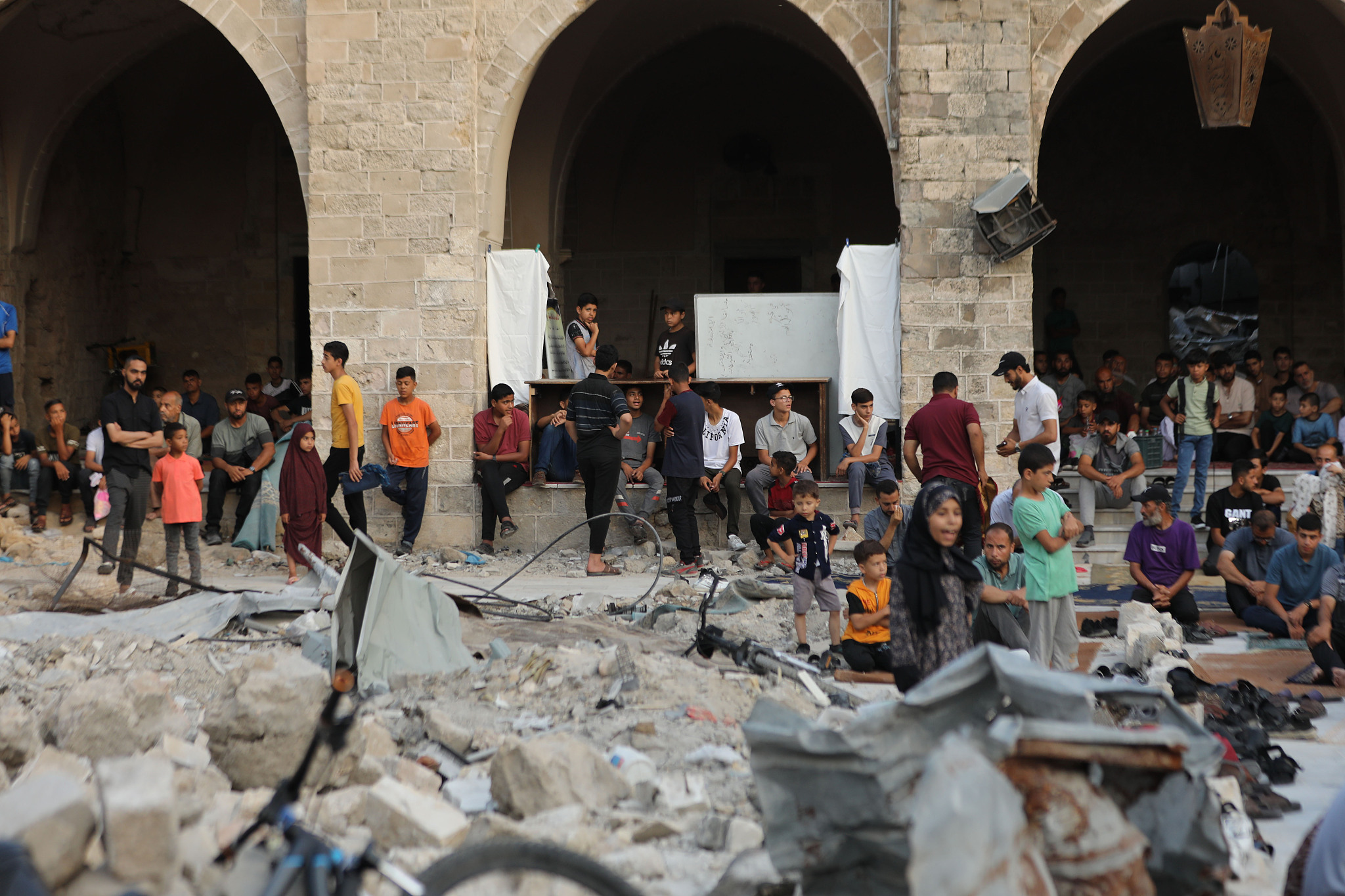 Palestinians in Gaza City perform Eid al-Adha prayers next to the ruins of the historic 