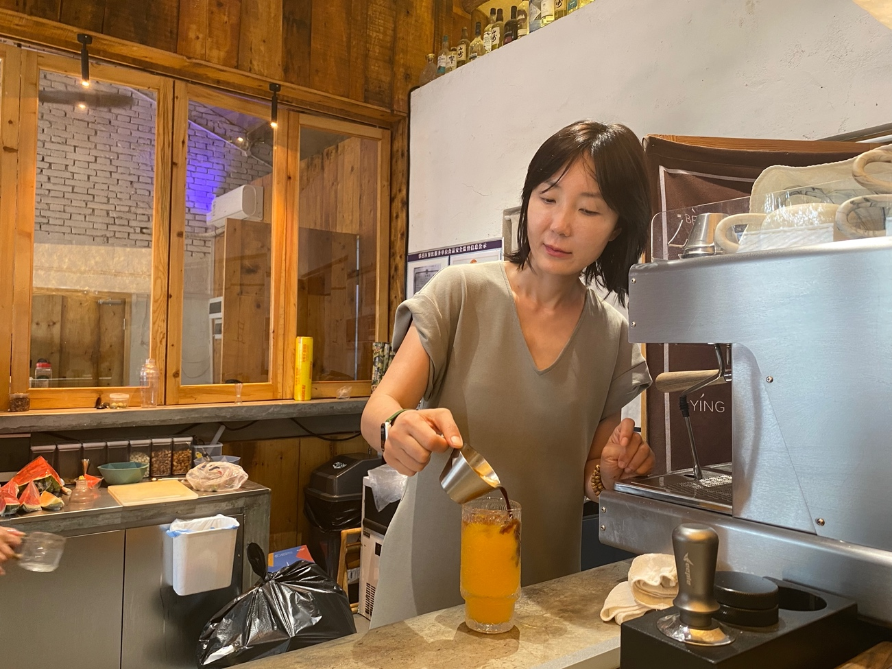Wang Huiting makes drinks at Two Tree Café, which she established in Liyukou Village in Xi'an City, northwest China's Shaanxi Province, June 20, 2024. /CGTN