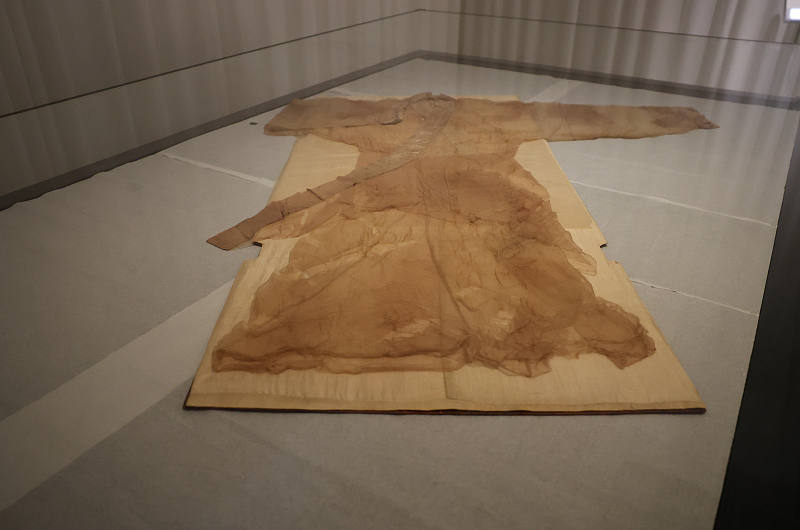 A plain unlined gauze gown with a curved hem unearthed from Lady Xin Zhui's tomb is on display at the Hunan Museum in Changsha, Hunan Province, June 22, 2024. /CFP