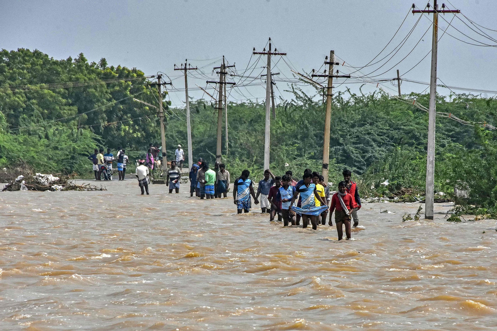 People wade through a flooded road after heavy rains in Thoothukudi, India, December 20, 2023. /CFP