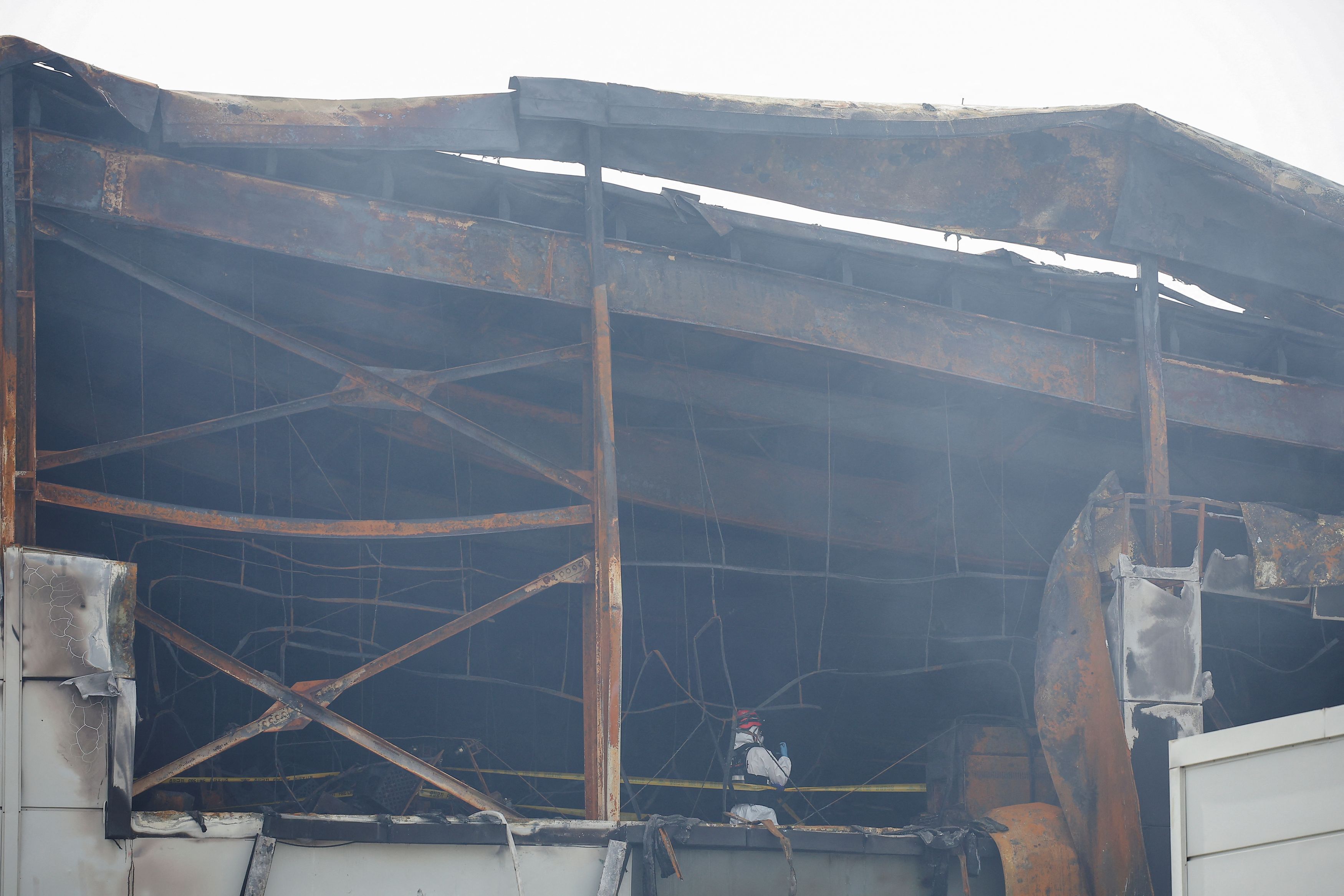 A firefighter inspects the site of a deadly fire at a lithium battery factory owned by South Korean battery maker Aricell in Hwaseong, South Korea, June 24, 2024. /Reuters