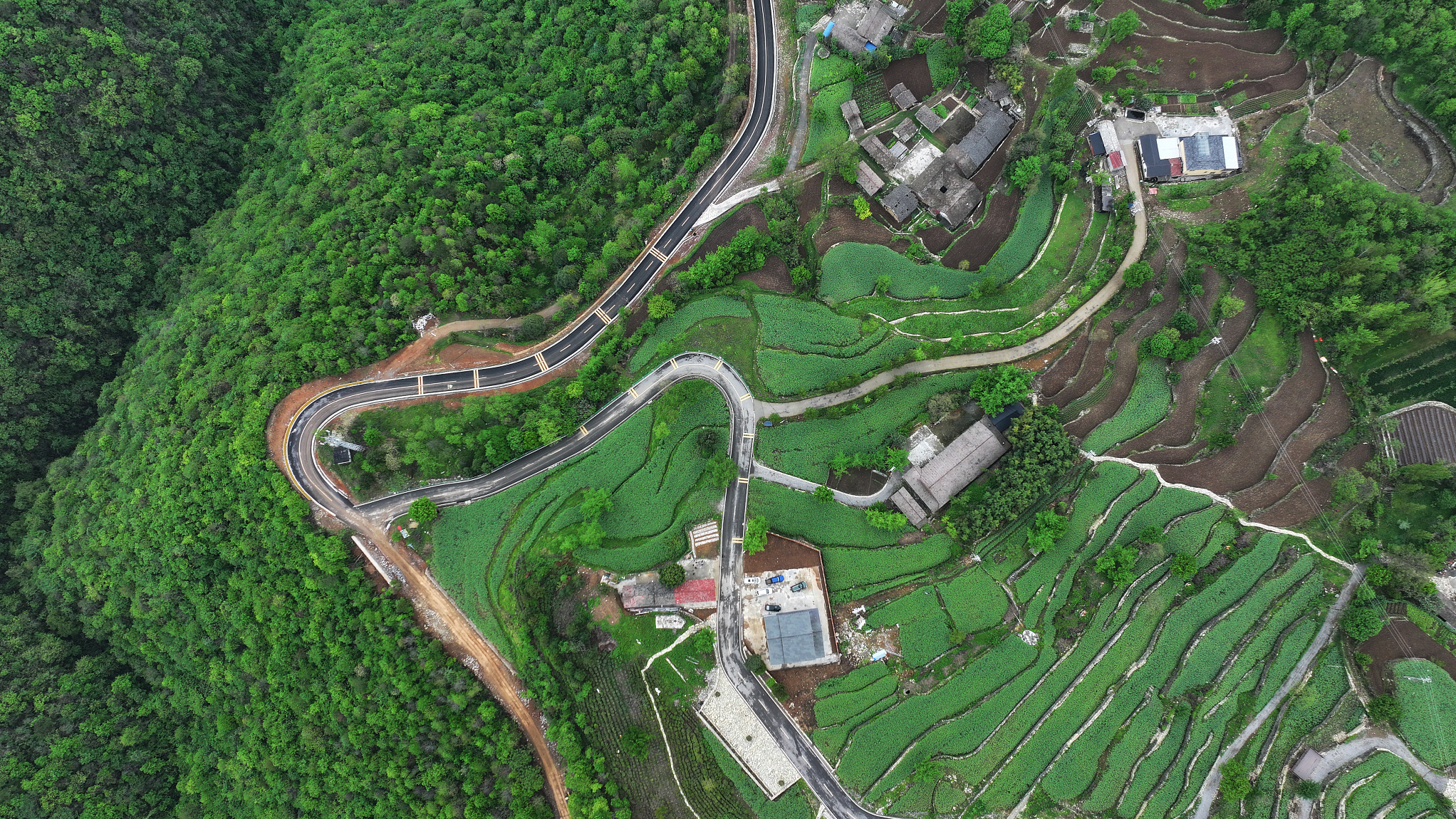 An aerial view shows a road through the forests in Yuan'an County, an advanced afforestation county in Hualin Town, Yichang City, Hubei Province, China, April 16, 2024. Hubei Province has made considerable efforts to control water and soil loss through afforestation, grassland planting and the comprehensive management of small watersheds. In Yuan'an, the soil and water conservation rate has increased from 85.72 percent in 2016 to 87.6 percent in 2023. /CFP