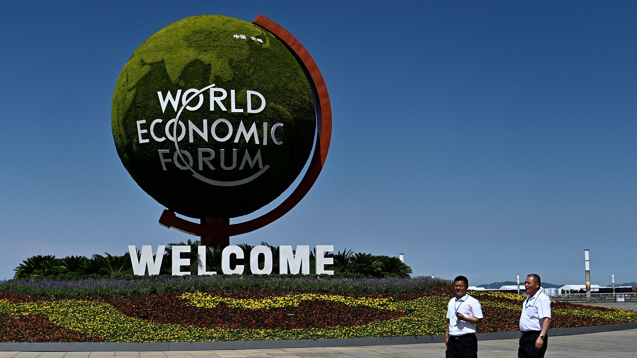People walk past a welcome sign at the World Economic Forum Annual Meeting of the New Champions in Dalian, northeast China's Liaoning Province, June 25, 2024. /CFP