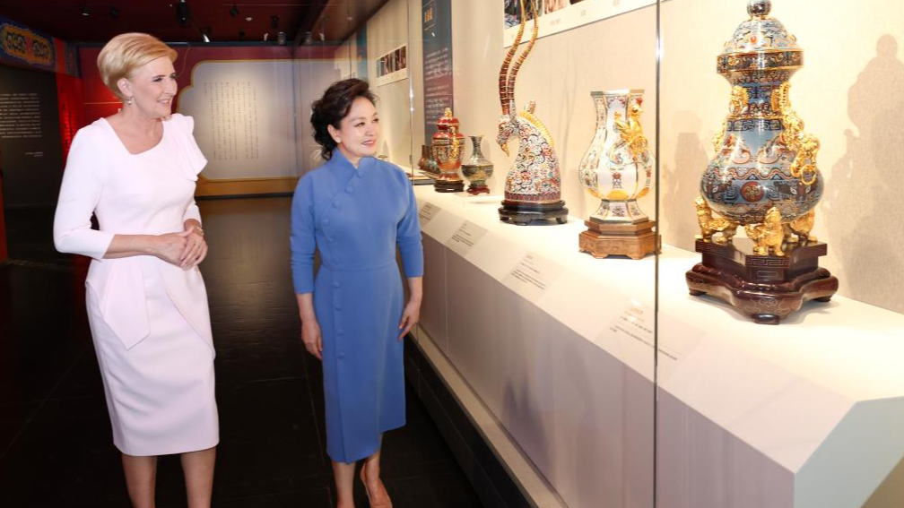 Peng Liyuan (R) and Agata Kornhauser-Duda visit an art exhibition on Beijing's intangible cultural heritage that showcases Chinese craftsmanship, at the National Center for the Performing Arts in Beijing, China, June 24, 2024. /Xinhua