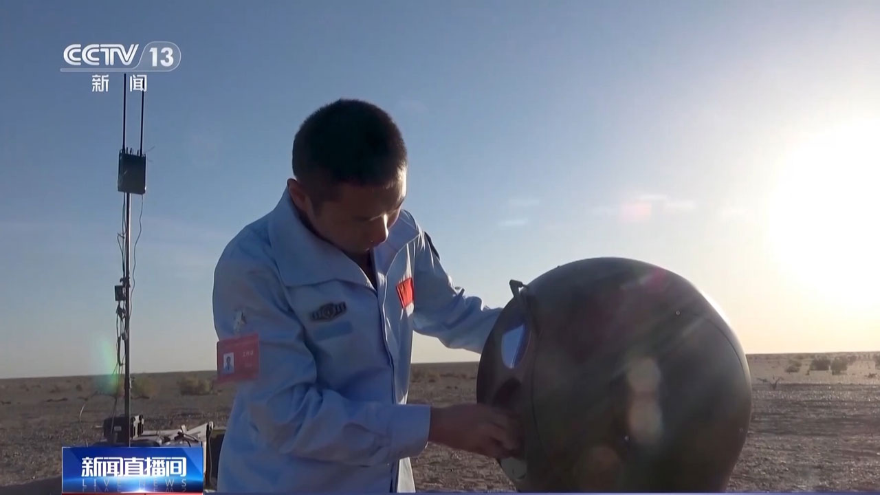 A member of the Chang'e-6 lunar mission's ground team examines equipment for capturing the probe's return. /CMG