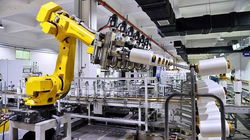 A robot works on the production line in the intelligent workshop of a chemical fiber textile enterprise in Changle District, Fuzhou City, Fujian Province, China, May 31, 2023. /CFP