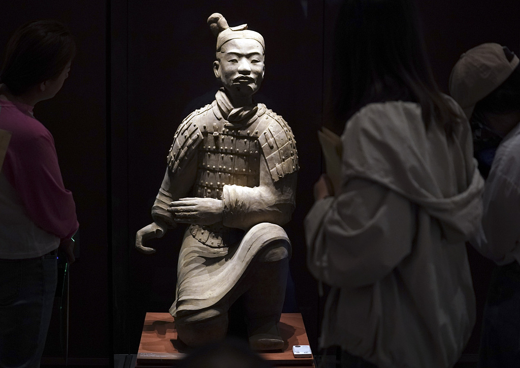 A file photo shows people admiring the kneeling archer terracotta warrior at the China National Archives of Publications and Culture in Beijing. /CFP