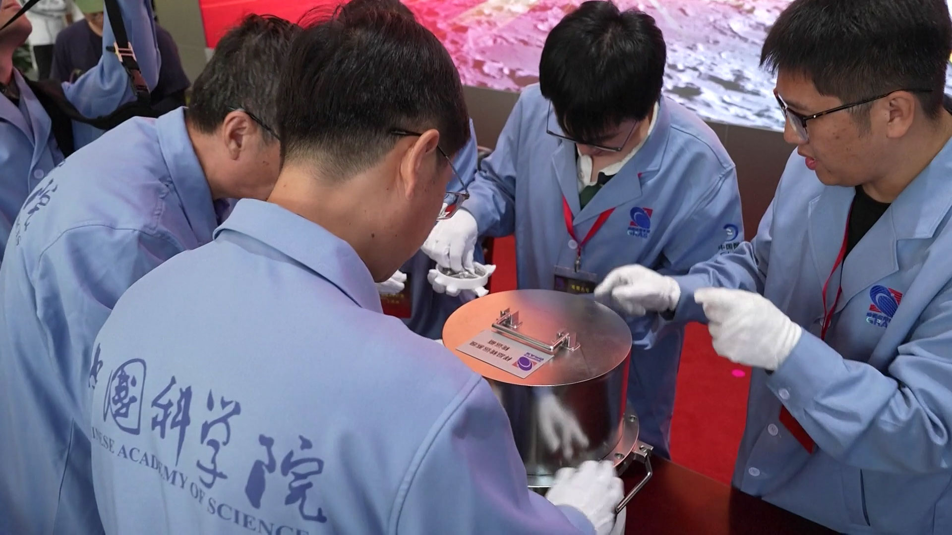 Researchers from the Chinese Academy of Sciences examine a container from the Chang'e-6 return capsule, Beijing, China, June 26, 2024. /CFP