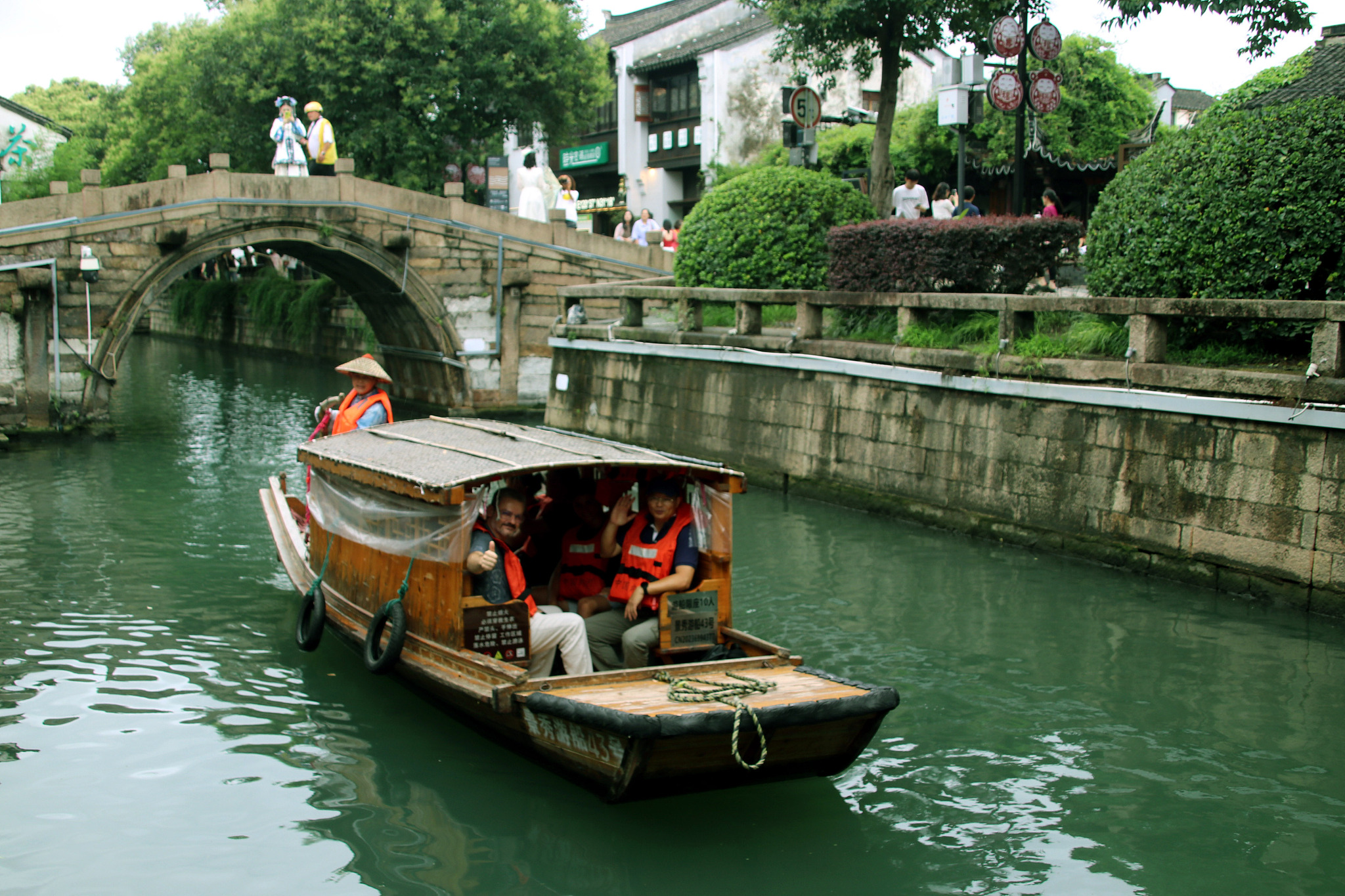 Tourists took a hand-cranked wooden boat in the water lane of Pingjiang Road in Suzhou, east China's Jiangsu Province, June 27, 2024. /CFP