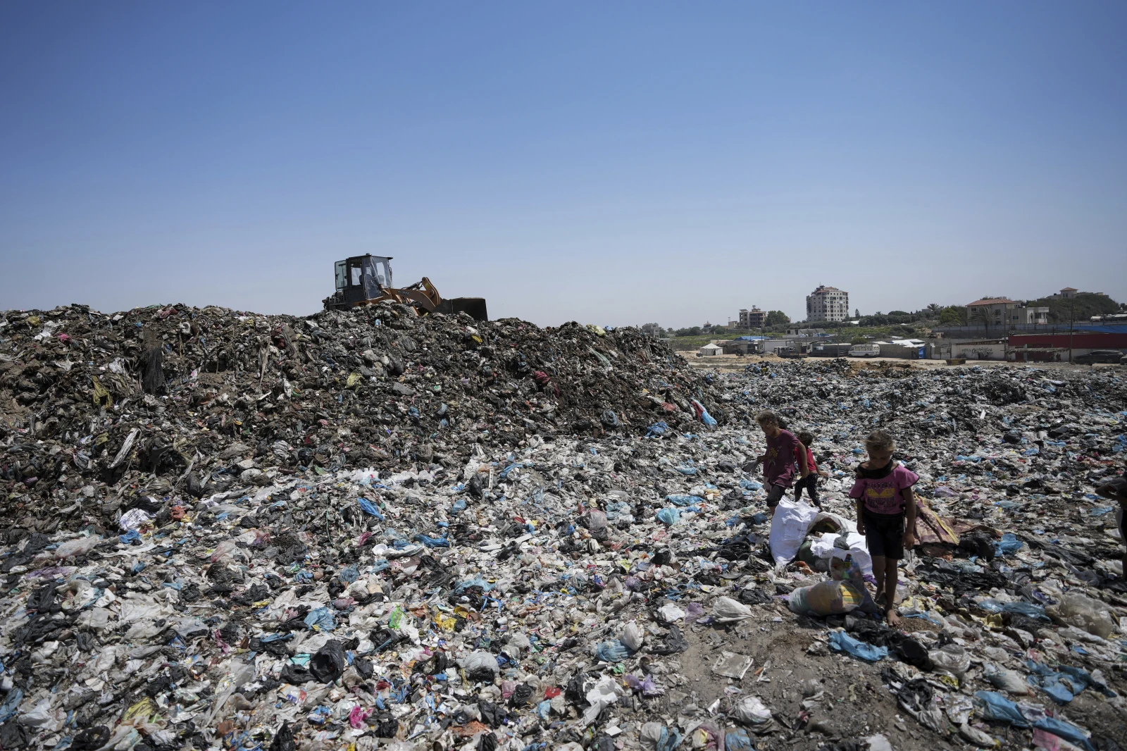 Palestinians sort through trash at a landfill in Nuseirat refugee camp, Gaza Strip, June 20, 2024. /AP