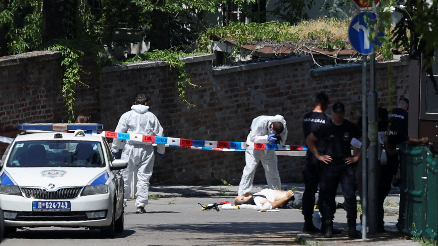 A person lies on the ground as police officers guard the area after an attack near the Israeli embassy in Belgrade, Serbia, June 29, 2024. /Reuters