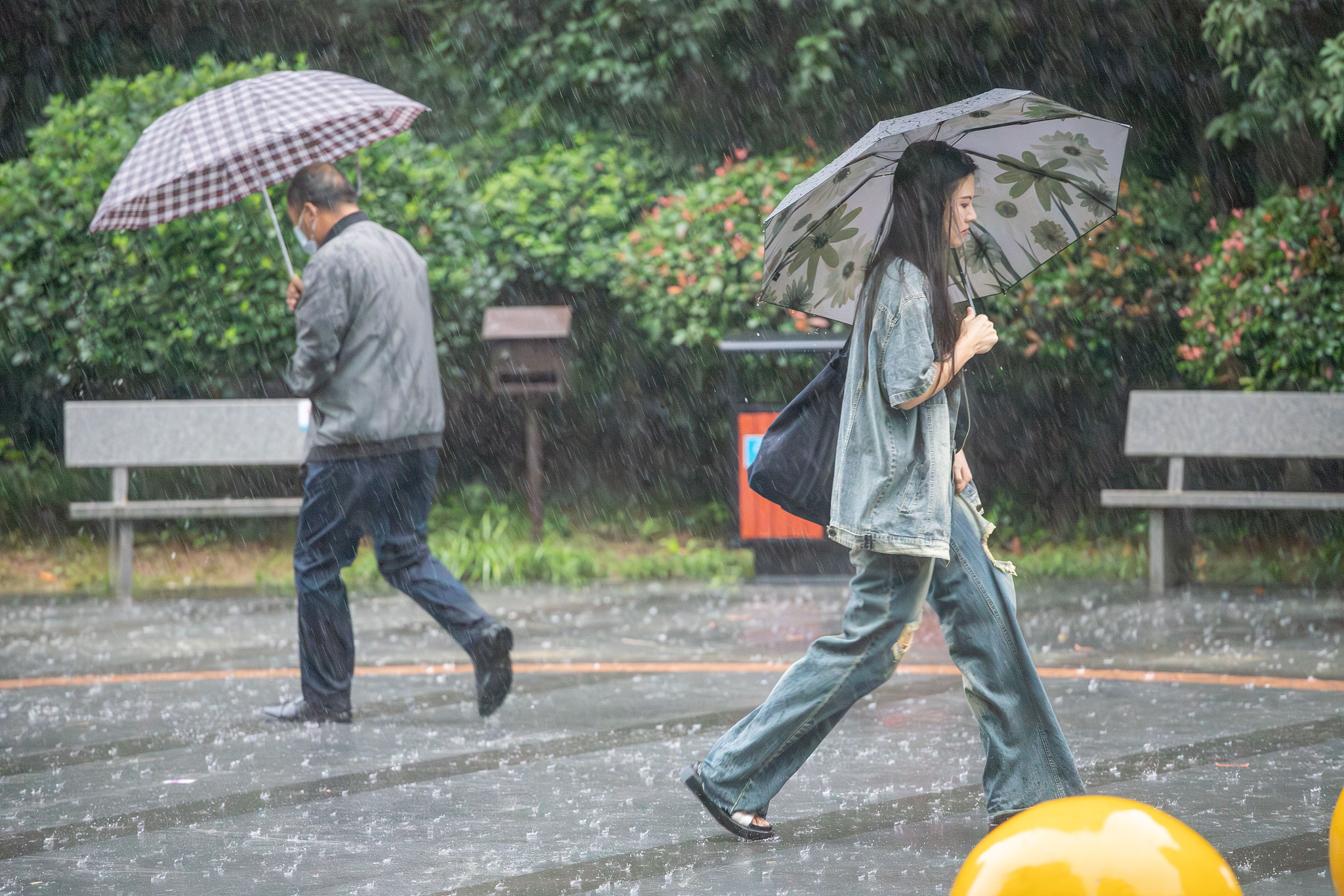 People walk in the rain as heavy rainfall hits Wuhan City of central China's Hubei Province, June 28, 2024, . /CFP