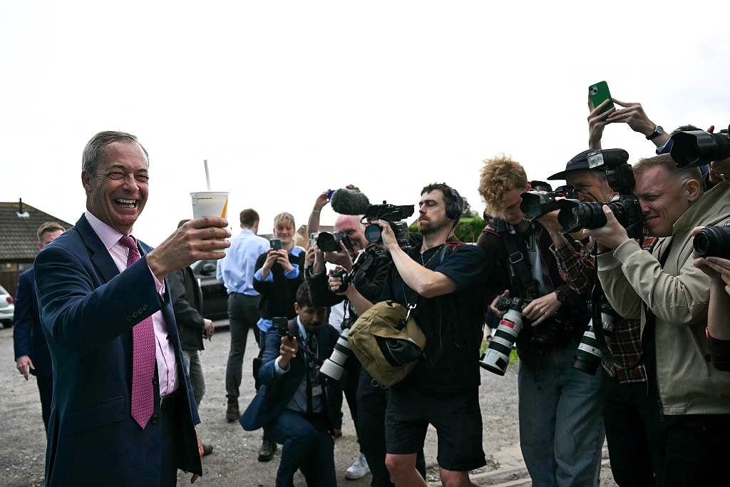 Reform leader Nigel Farage poses with a drink similar to the one thrown at him earlier in the day, during a general election campaign launch in Clacton-on-Sea, June 4, 2024. /CFP