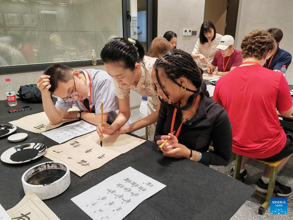 A Chinese teacher demonstrates calligraphy skills for U.S. youths from Valley High School at Shijiazhuang Foreign Language School in Shijiazhuang, north China's Hebei Province, June 8, 2024. /Xinhua