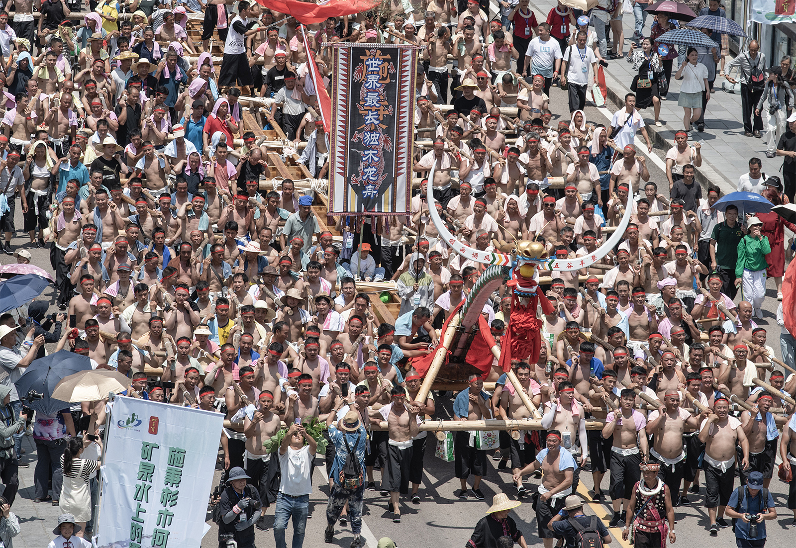 A total of 1,472 men carry a 99-meter-long canoe dragon boat during the opening parade of this year's Canoe Dragon Boat Festival of the Miao ethnic group in Shibing County, Guizhou Province on June 15, 2024. /CFP