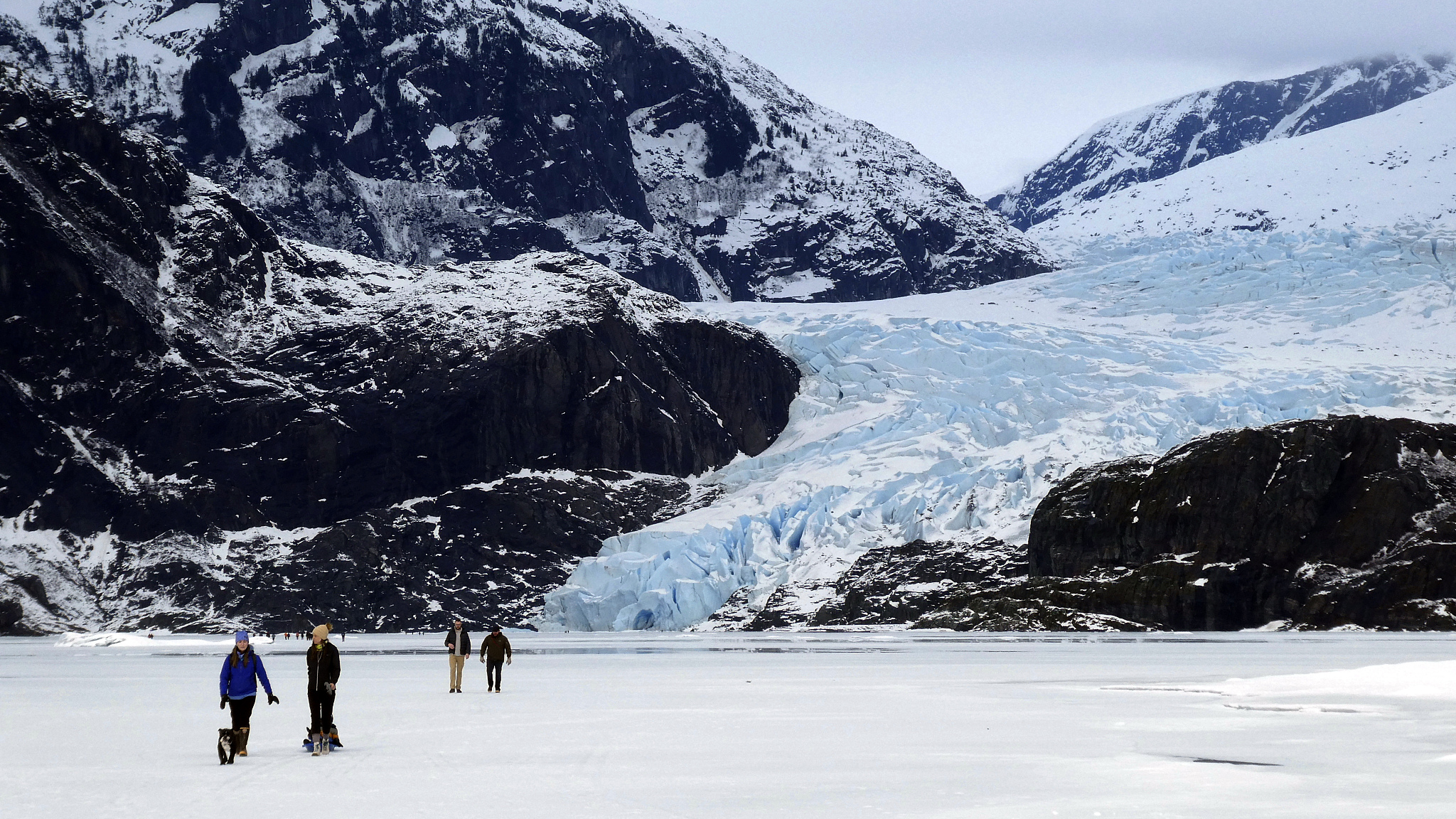 People walk on a frozen Mendenhall Lake with Mendenhall Glacier in the background in Juneau, Alaska, February 18, 2024. /CFP 