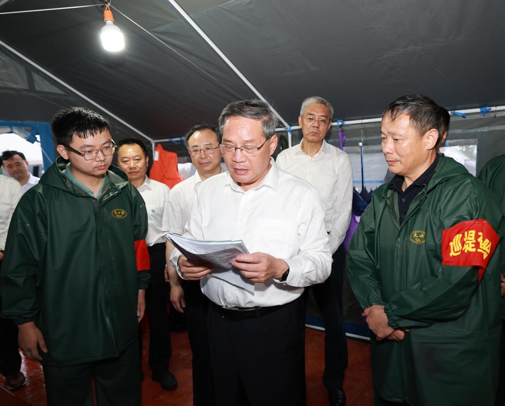 Chinese Premier Li Qiang, also a member of the Standing Committee of the Political Bureau of the Communist Party of China Central Committee, communicates with local emergency-response staff at a dike in Jiujiang, east China's Jiangxi Province, July 1, 2024. /Xinhua