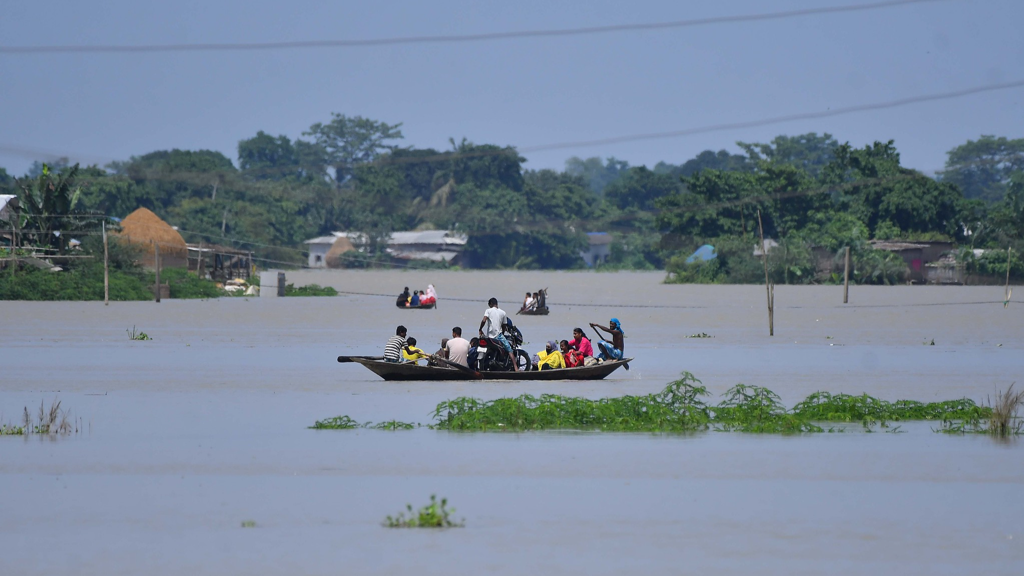 Villagers travel on a boat through a flooded village in Morigaon district of Assam, India, July 3, 2024. /CFP