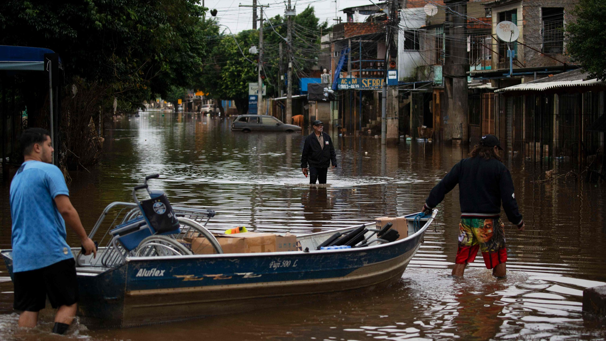 People walk through a flooded street in the Vila Farrapos neighborhood in Porto Alegre, Rio Grande do Sul State, Brazil, May 29, 2024. /CFP