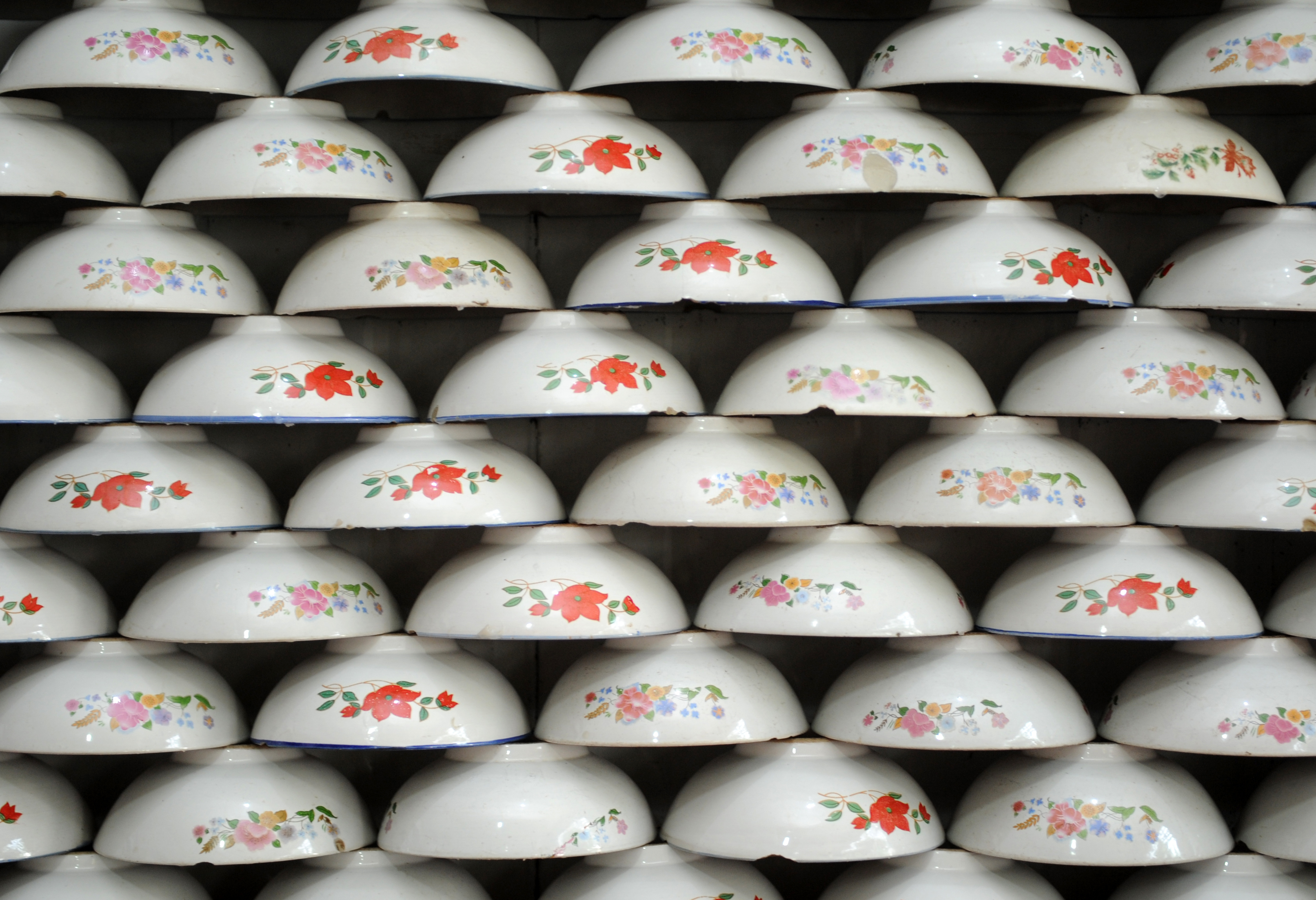 A matrix of bowls to contain wantuan stacked against a wall /IC