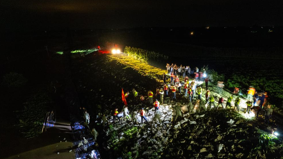 A drone photo shows rescuers working on a dike at Dongting Lake in Tuanzhou Township, Huarong County, under Yueyang City in central China's Hunan Province, July 5, 2024.  /Xinhua