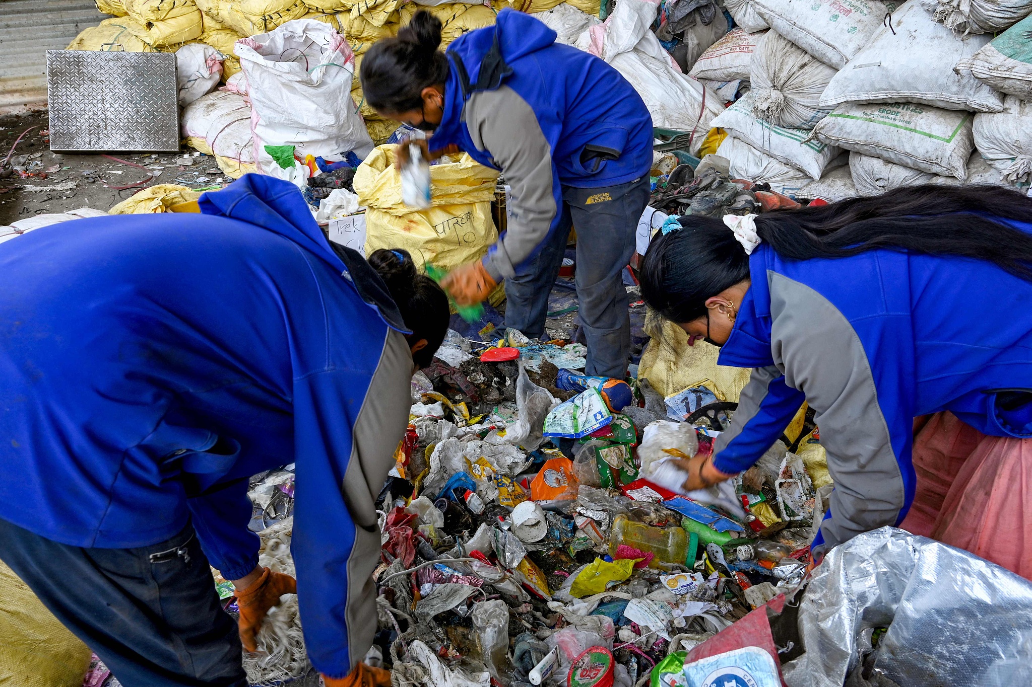 Workers segregate waste materials retrieved from Mount Qomolangma to recycle in Kathmandu, Nepal, June 12, 2024. /CFP