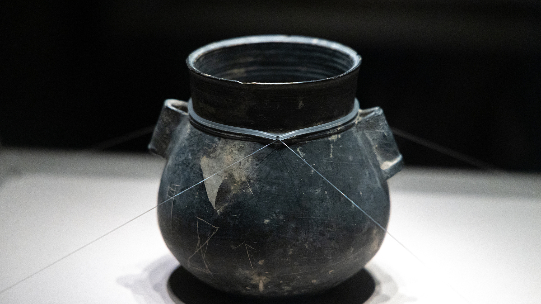 A black clay pot engraved with symbols is on display at the Liangzhu Museum in eastern China's Hangzhou. There are 12 inscriptions on its body, which are of great value to research on the origin of Chinese characters. /VCG