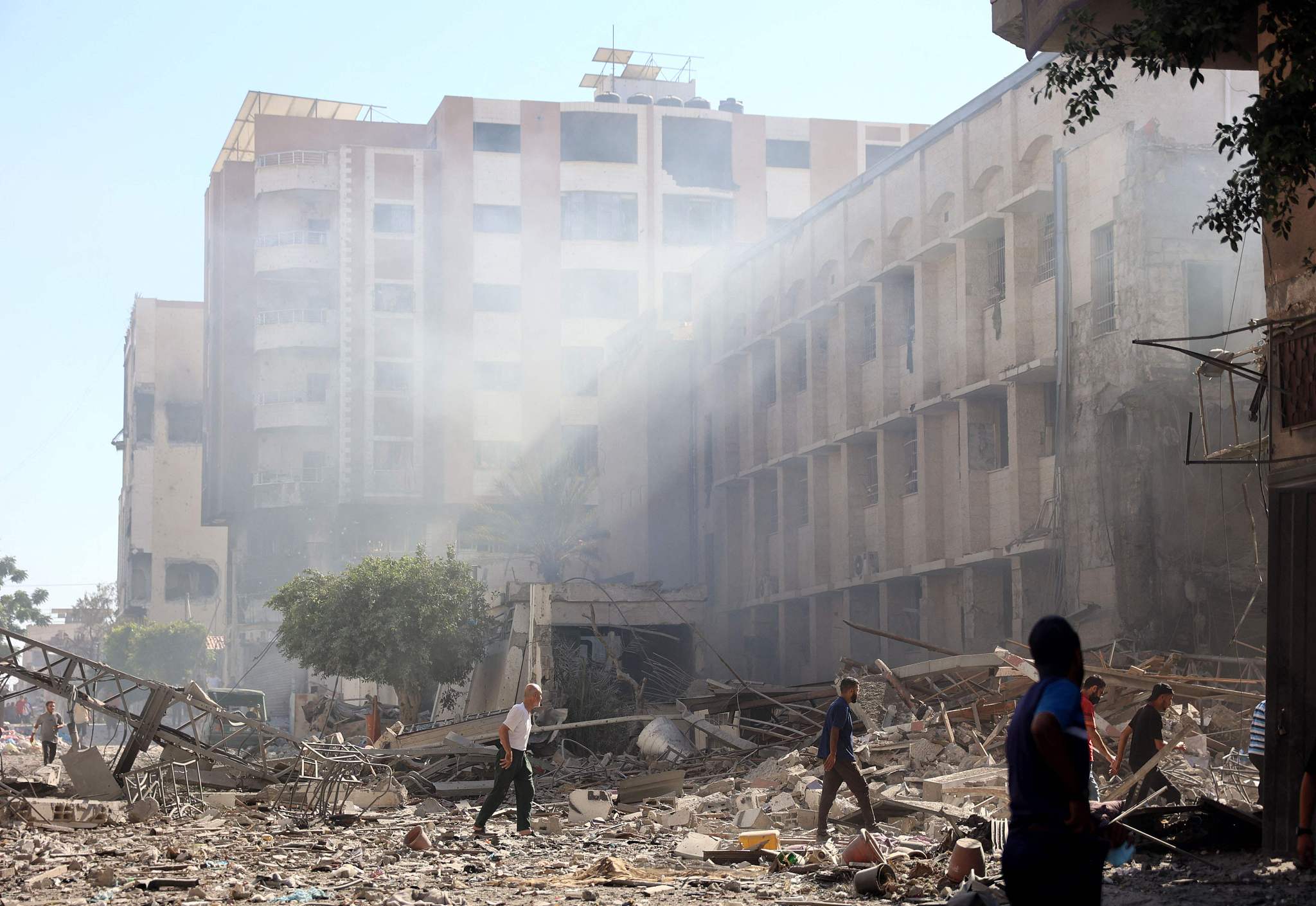 Palestinians walks on the rubble and debris of the Latin Patriarchate Holy Family School after it was hit during Israeli military bombardment in Gaza City, July 7, 2024. /CFP